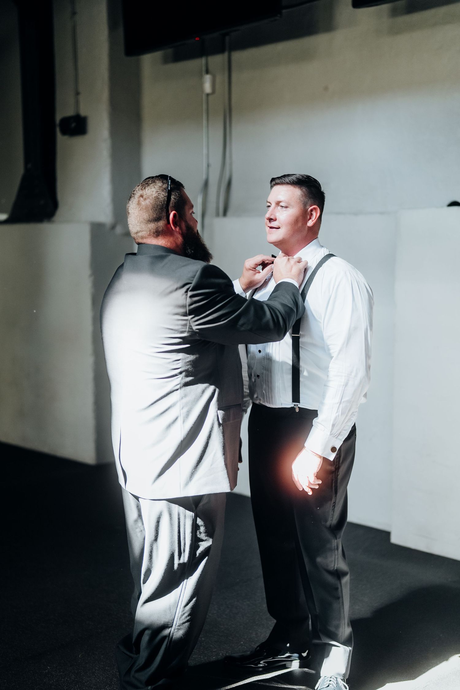 A dramatic sequence of two people in formal attire interacting in a dimly lit hallway.