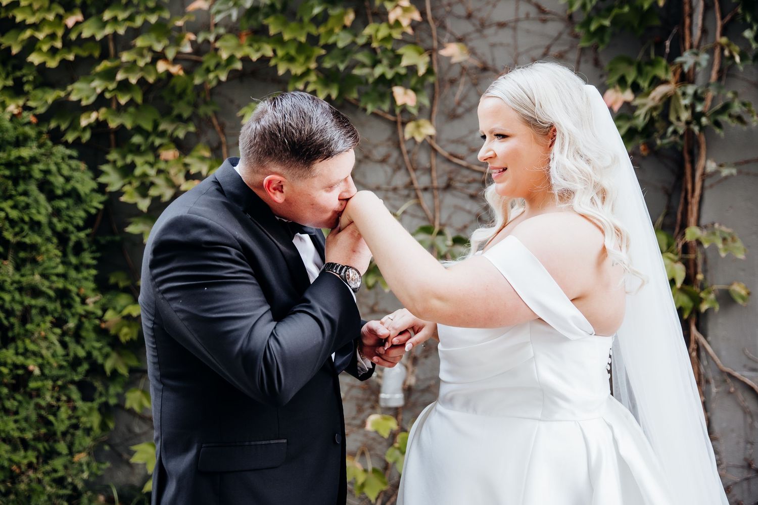 Joyful wedding couple sharing emotional moments in an outdoor garden setting.