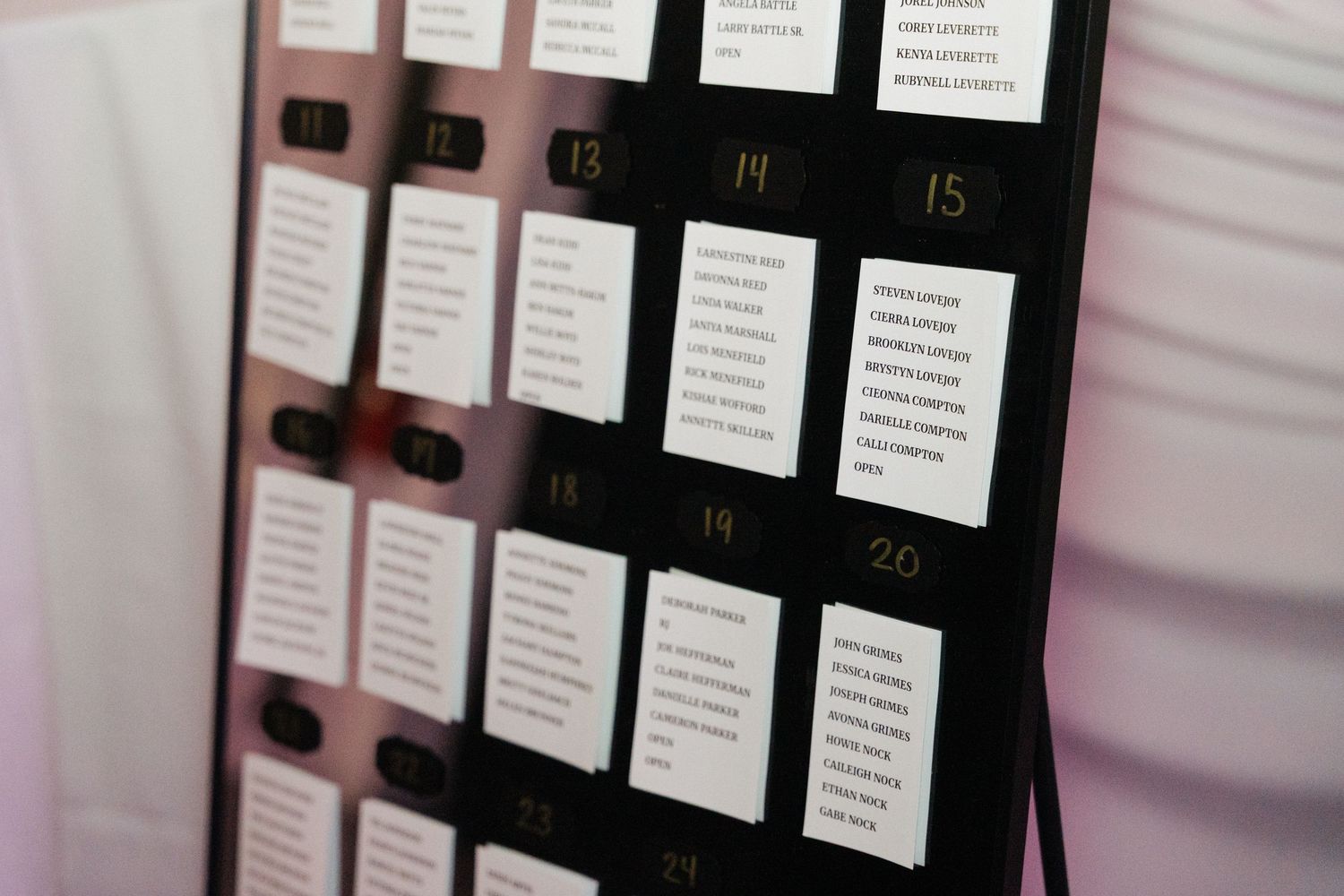 Close-up of black seating chart display with numbered table assignments.