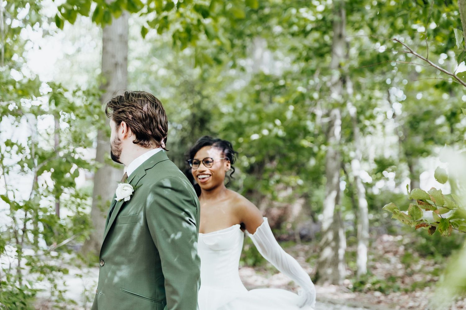 Couple shares an intimate moment in a garden setting with lush greenery and white decor.