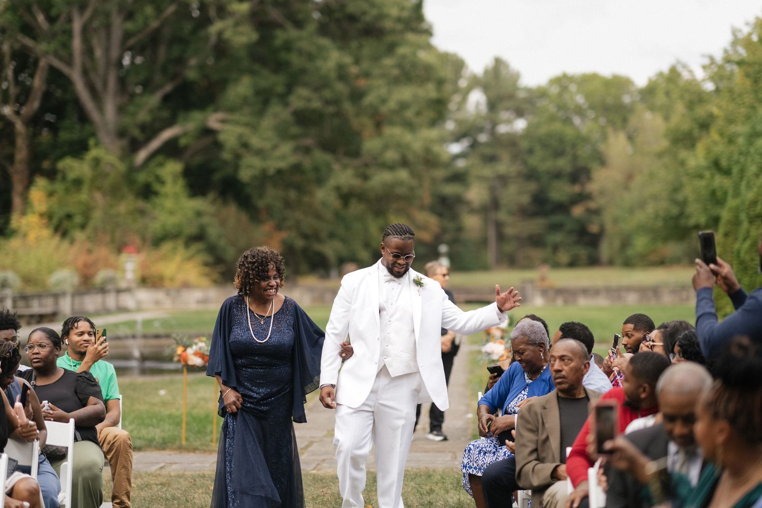 Wedding guests gather outdoors for a joyful celebration on a sunny day.