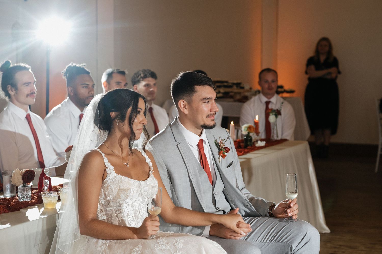Wedding reception scene with guests seated at tables with red accents.
