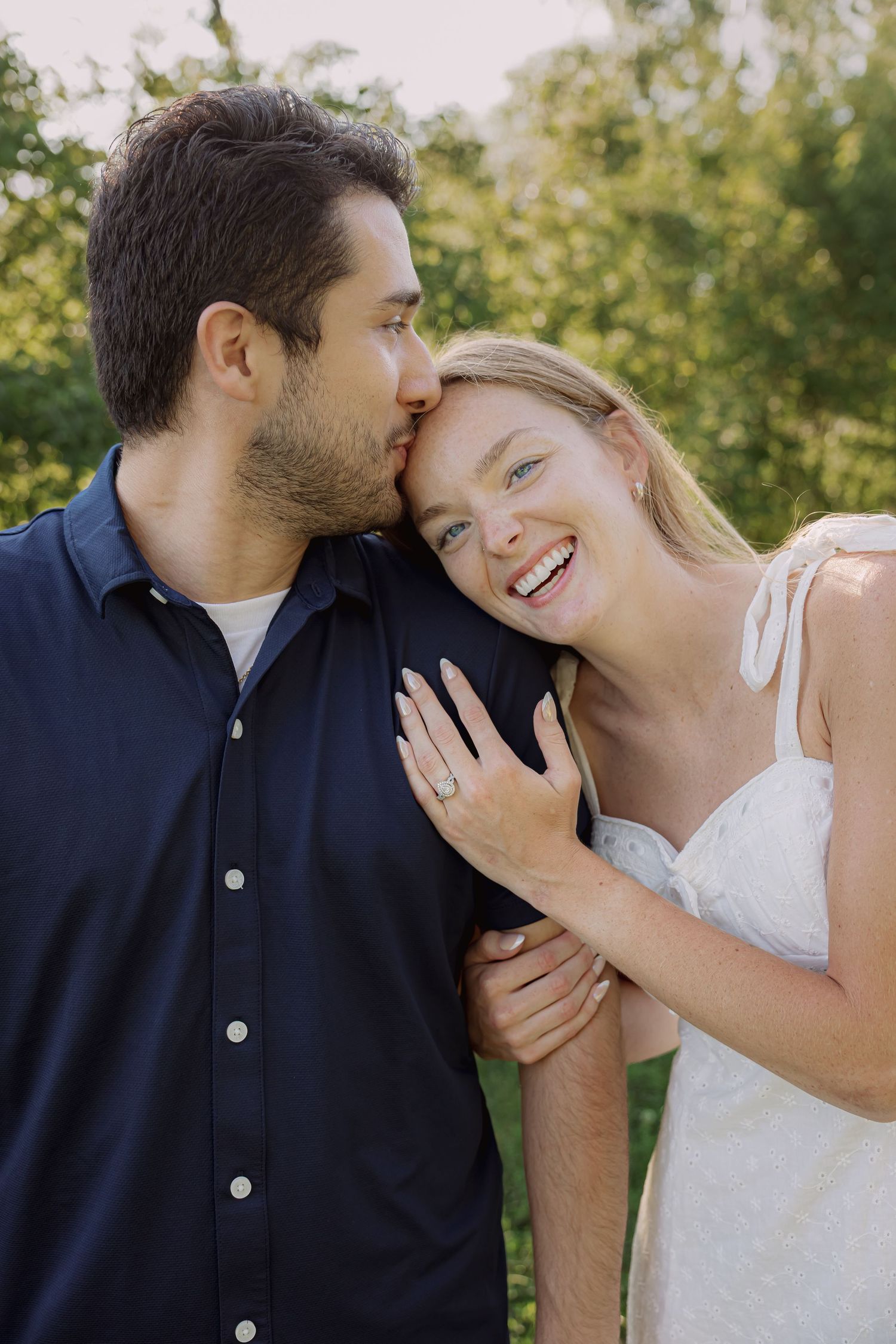 Tender romantic moment captured between couple in natural outdoor setting.
