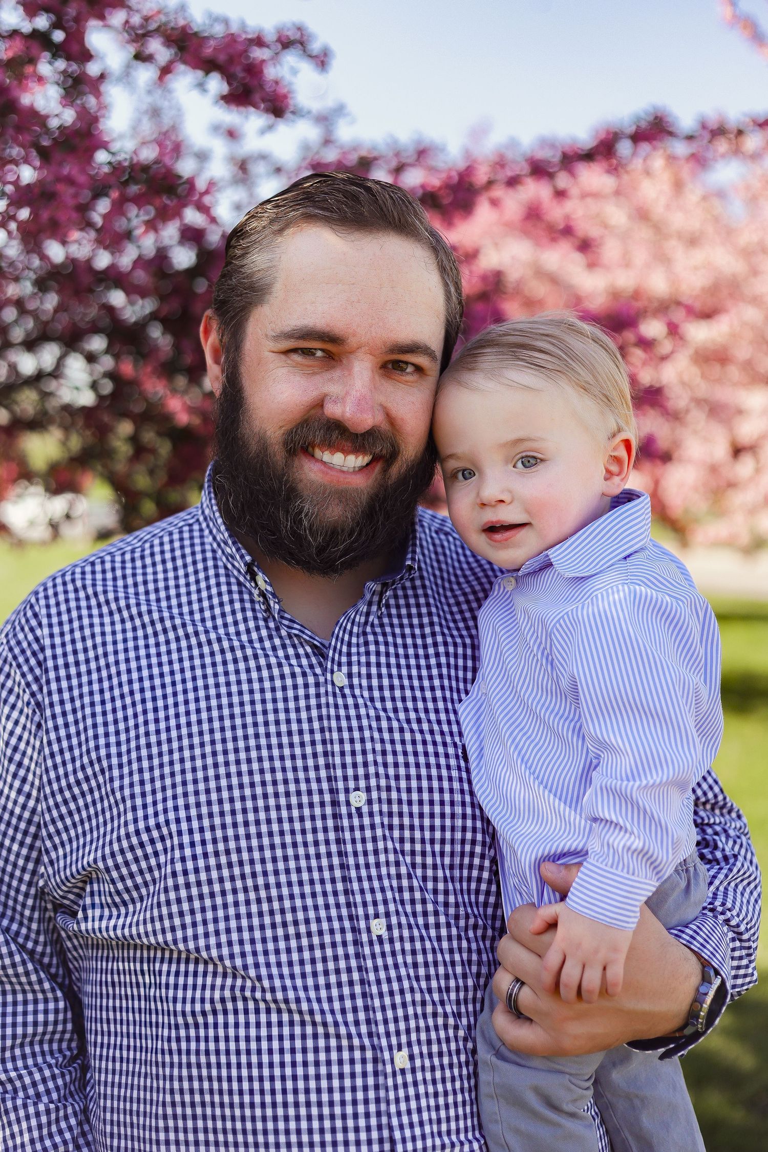 A heartwarming portrait taken under pink cherry blossoms in springtime.