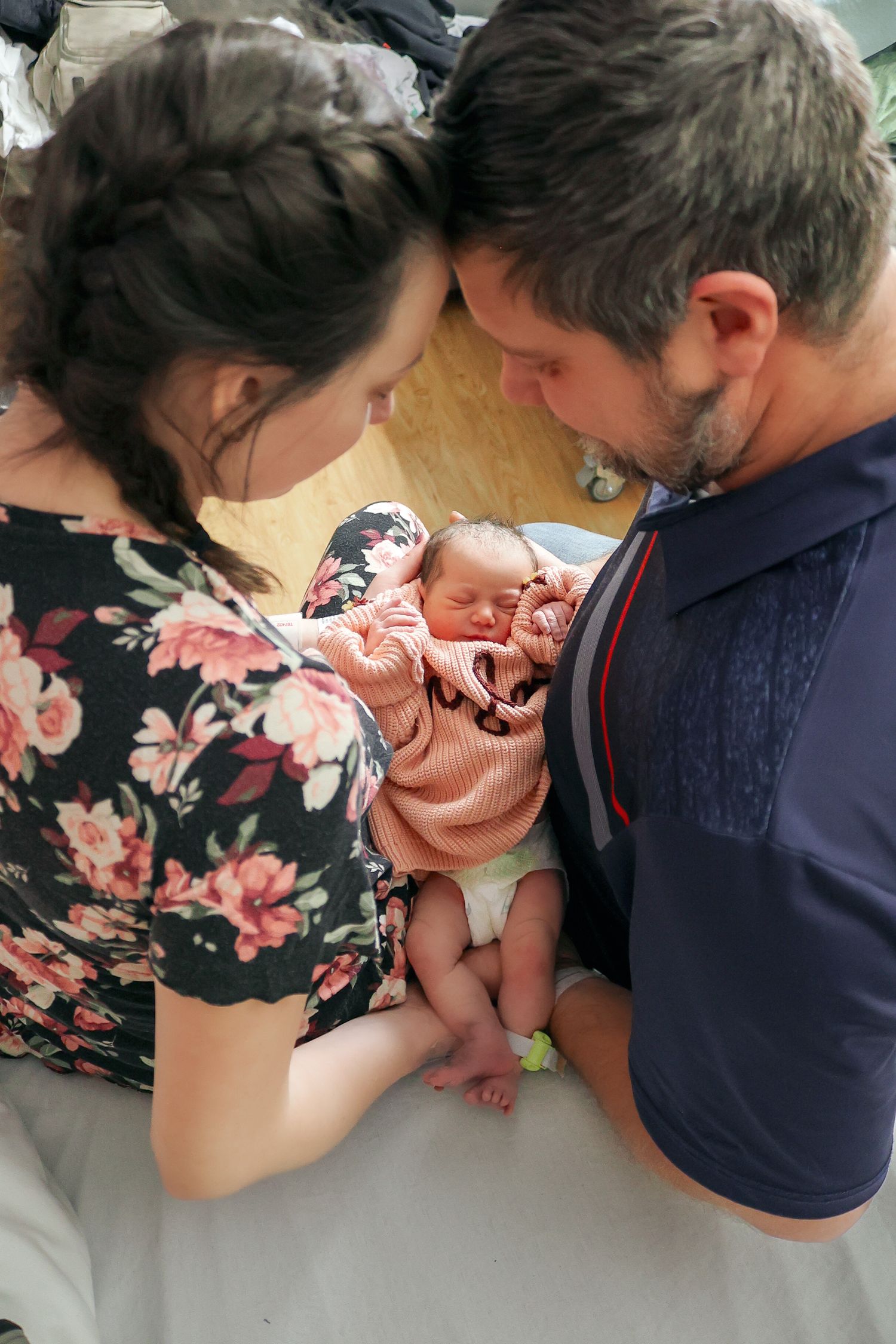 Parents admiring their newborn baby in the hospital room.