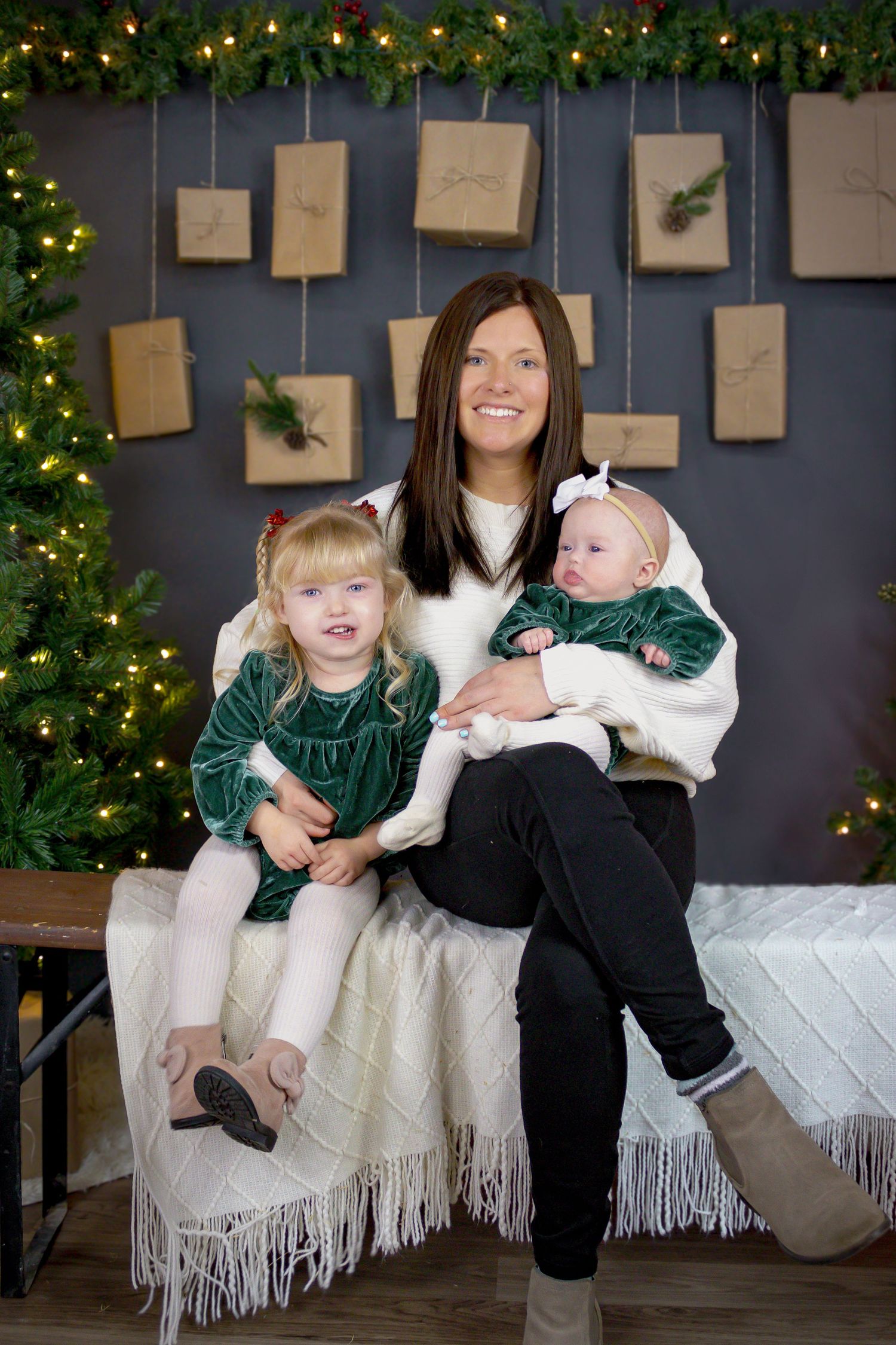 Holiday family photos with Christmas tree and paper decorations on blue wall.