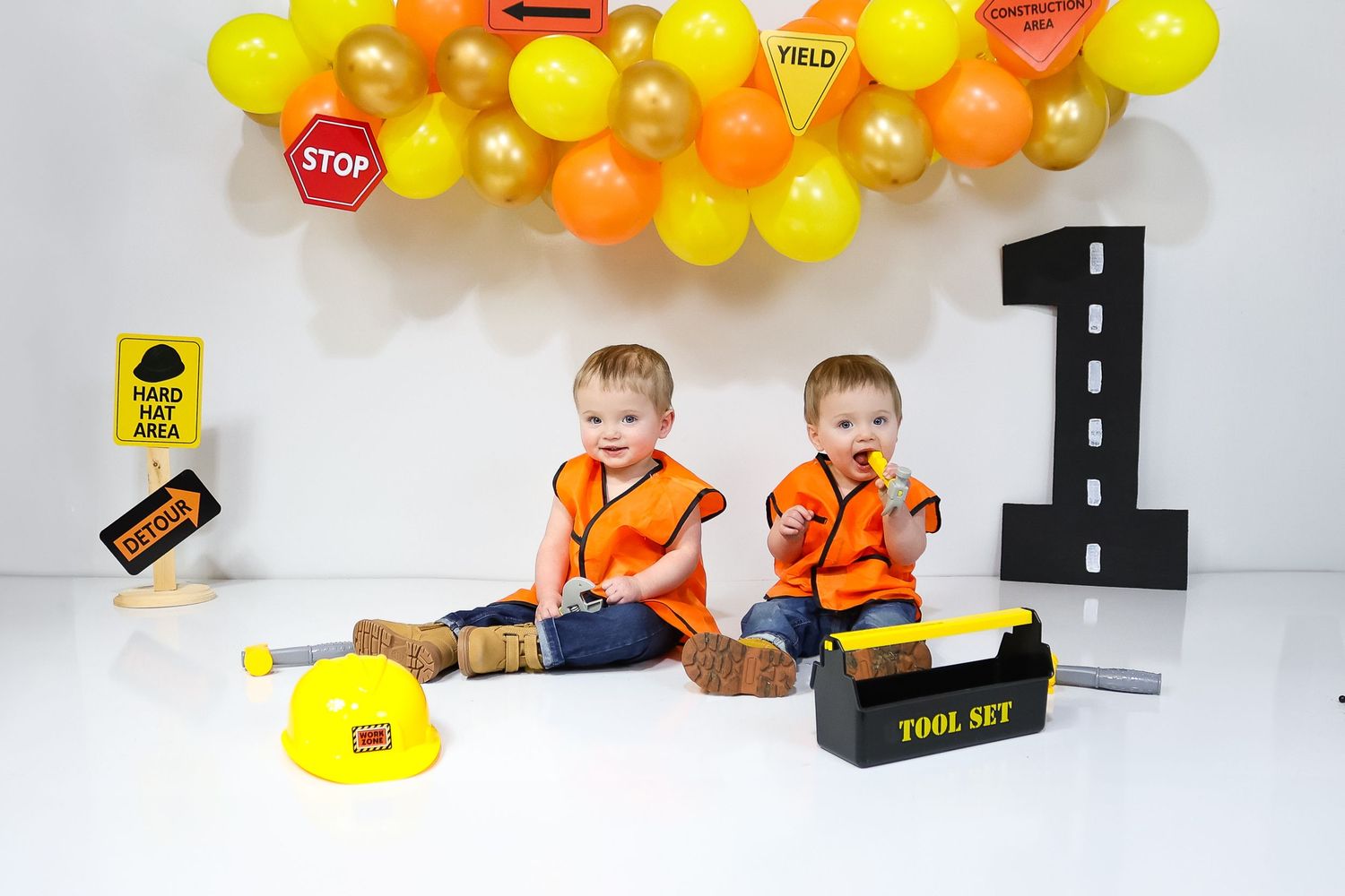 Construction zone themed birthday setup with road signs and yellow balloon garland.
