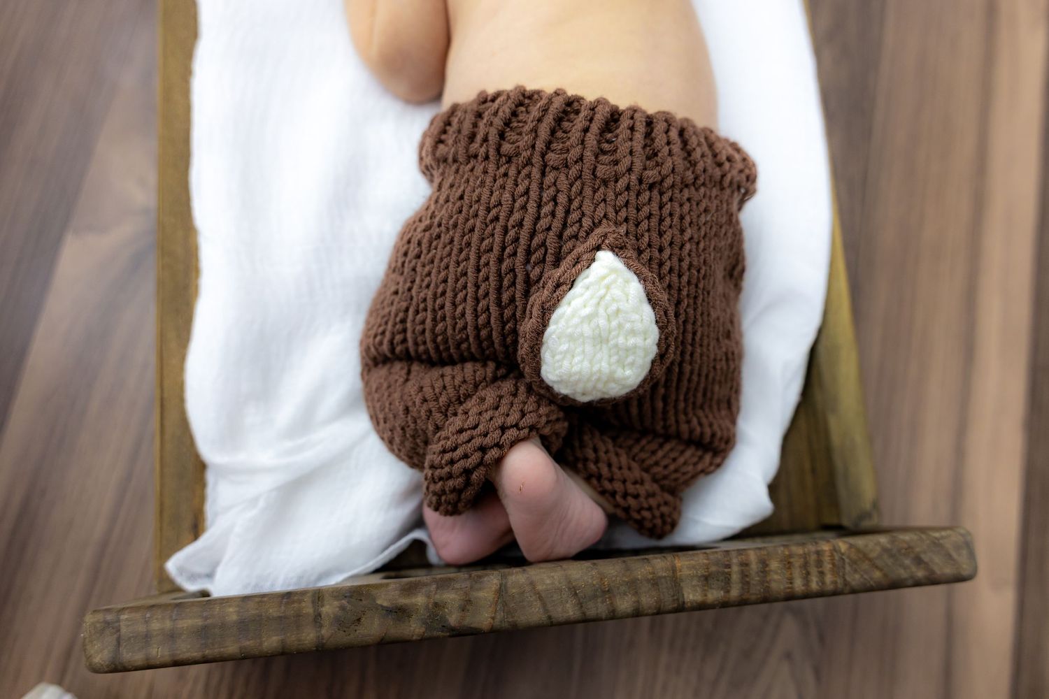 Brown knit baby hat with white heart detail shown from multiple angles on display.
