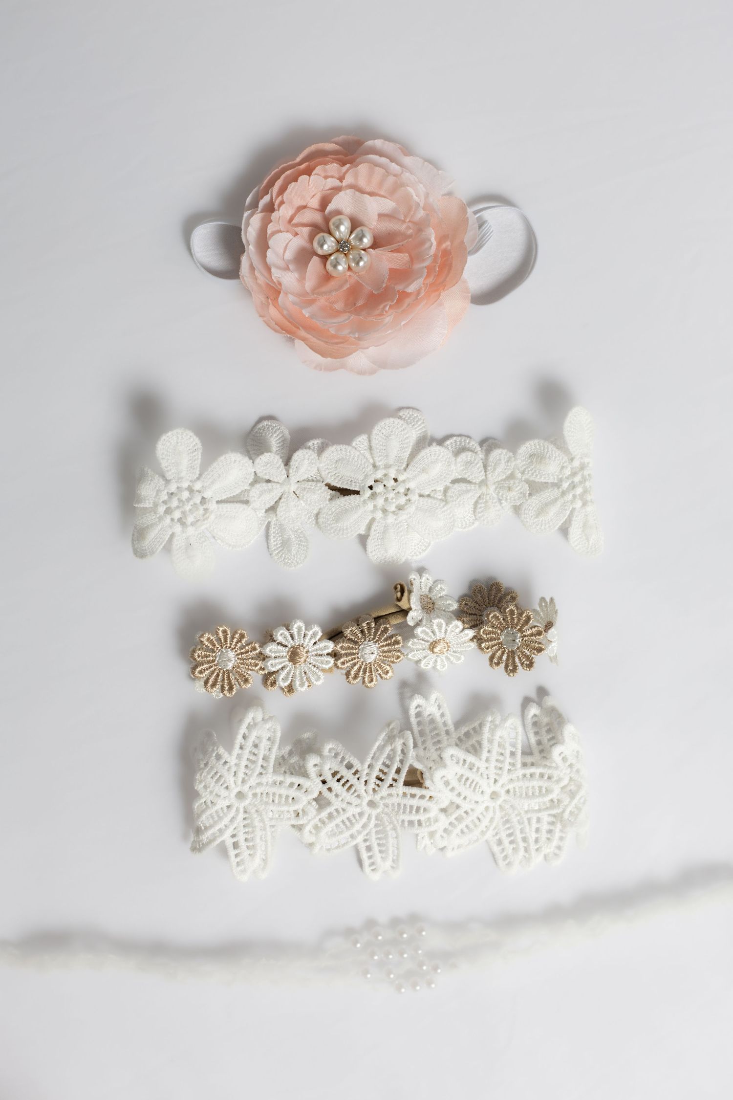Delicate lace headbands and peach flower hair accessories on white background.