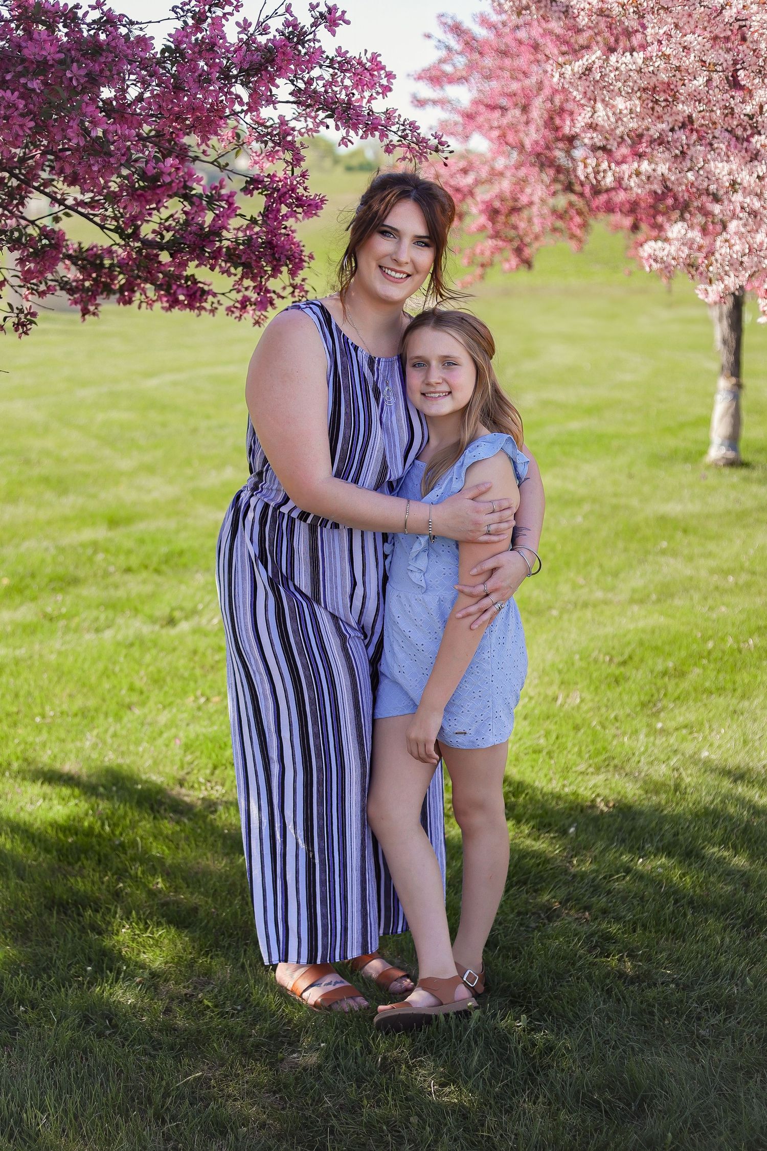 Sweet candid moments captured between family members under flowering trees.