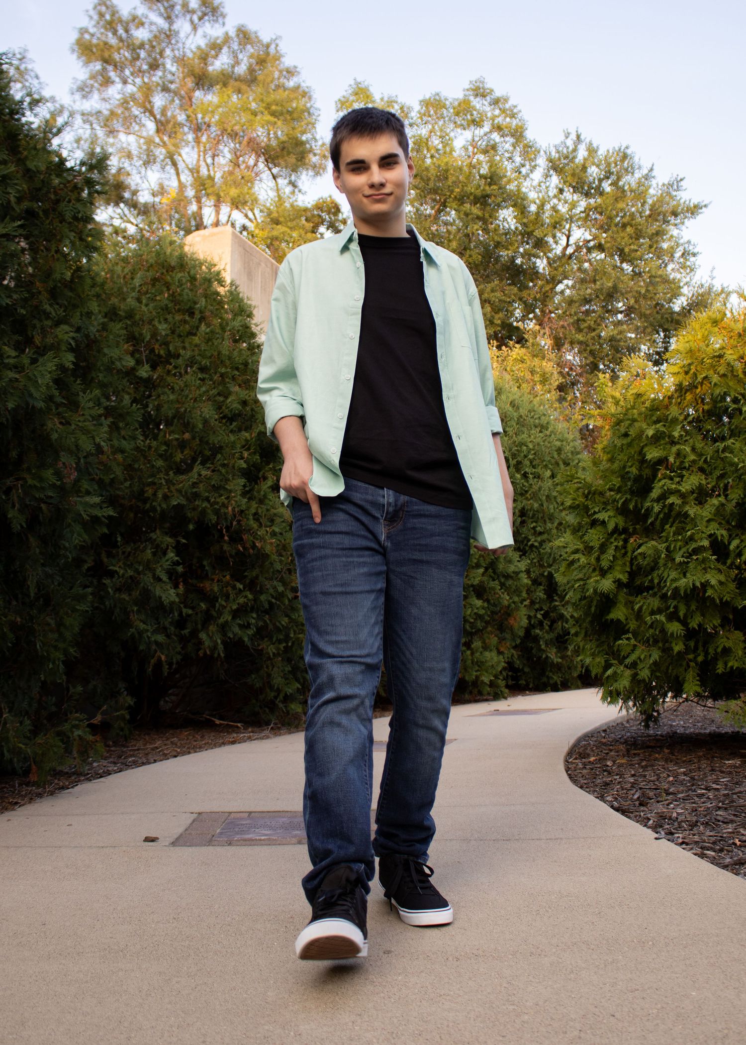 Series of walking poses on a concrete path surrounded by autumn trees and greenery.