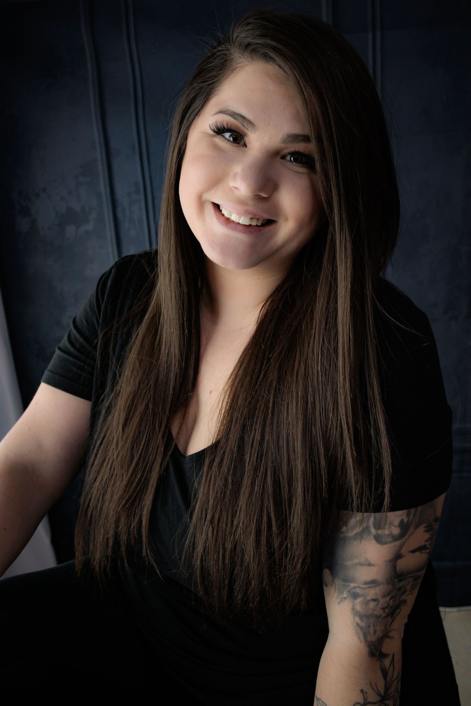 Studio portrait series featuring a photographer with tattoos in casual black attire.
