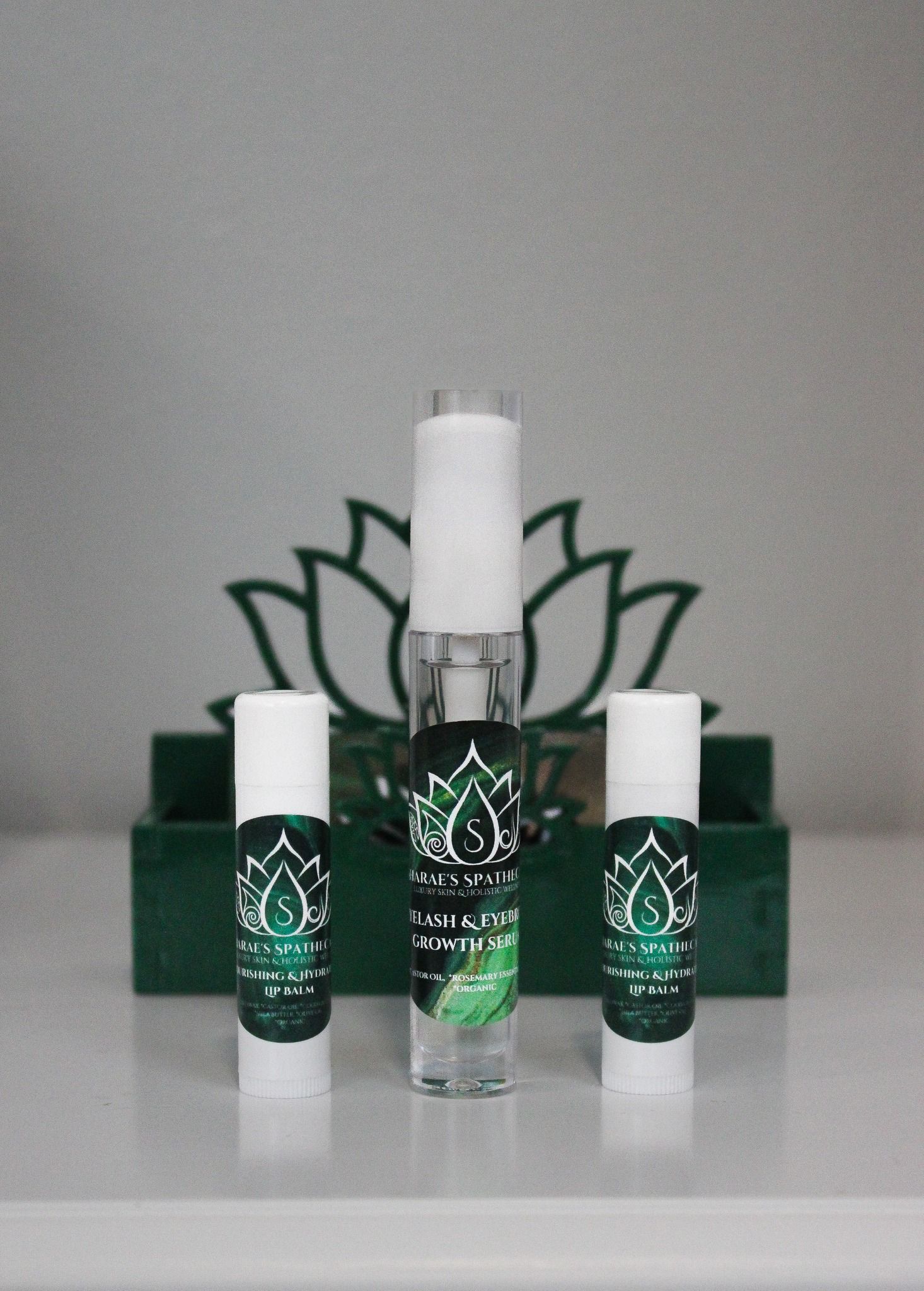White and green branded skincare or beauty product bottles displayed with lotus logo design.