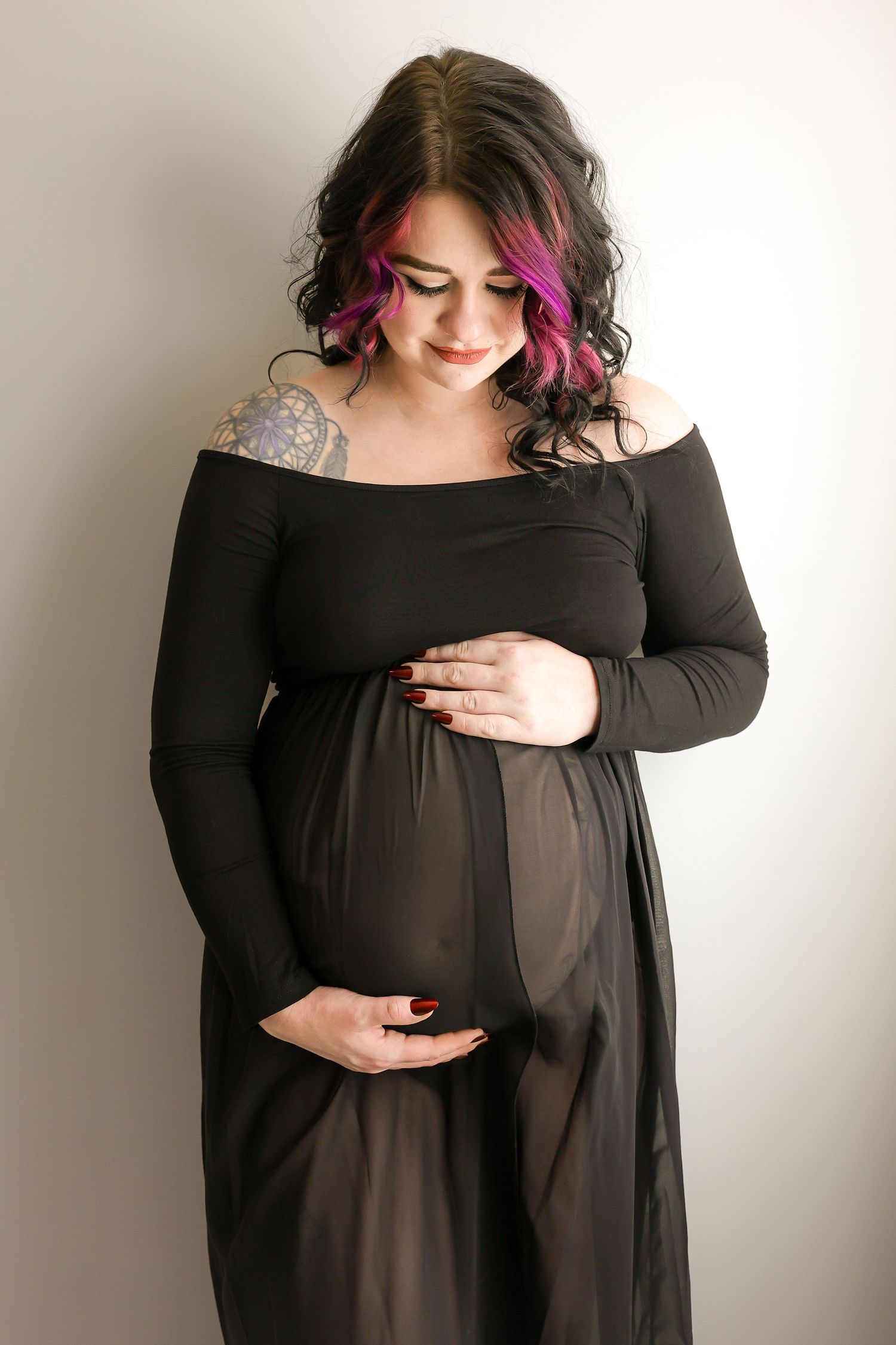 A series of maternity photos showing a person in a black dress with pink hair highlights against a white background.