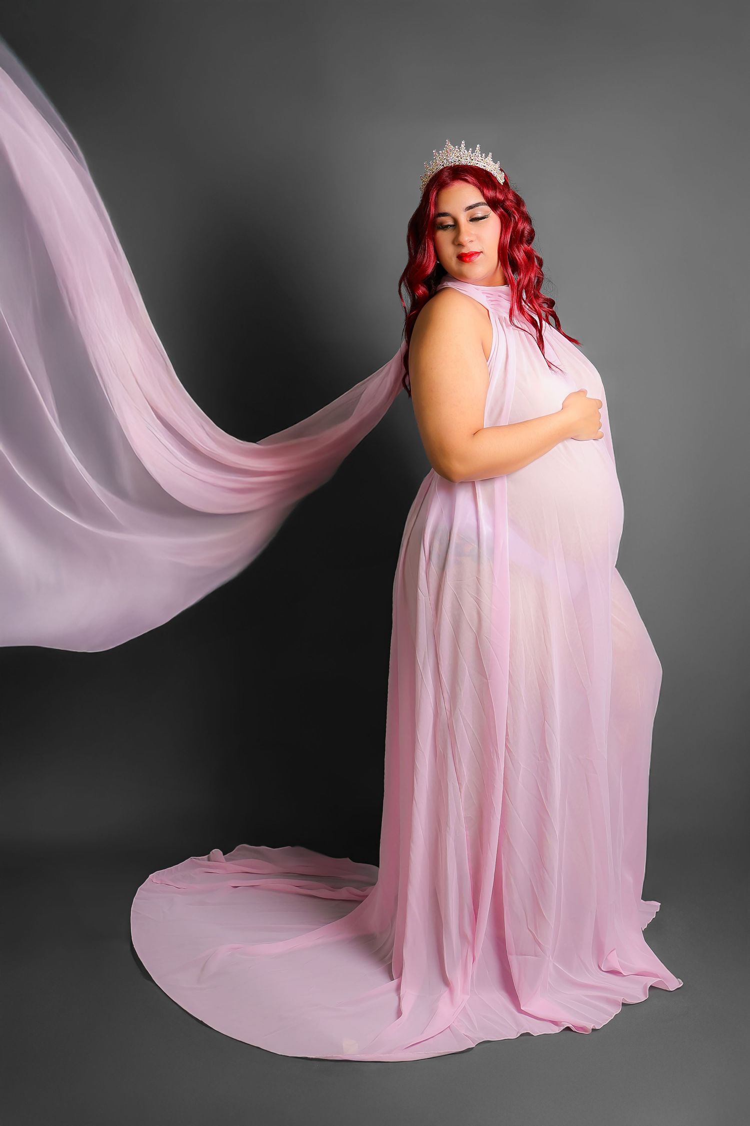 Ethereal portrait series with flowing pink fabric and dramatic lighting in a studio setting.