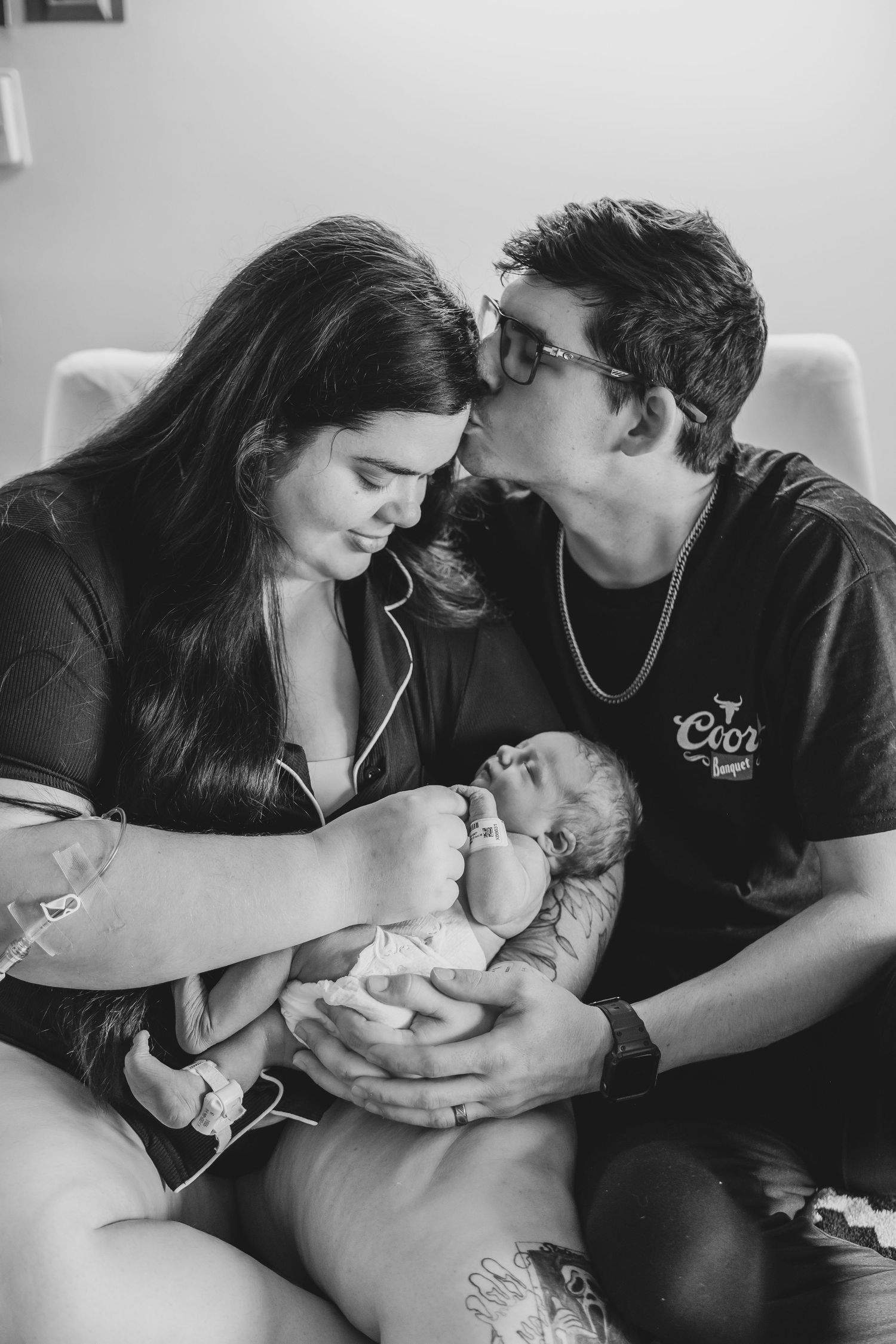 Black and white photo series showing intimate moments between parents and their newborn baby in hospital setting.