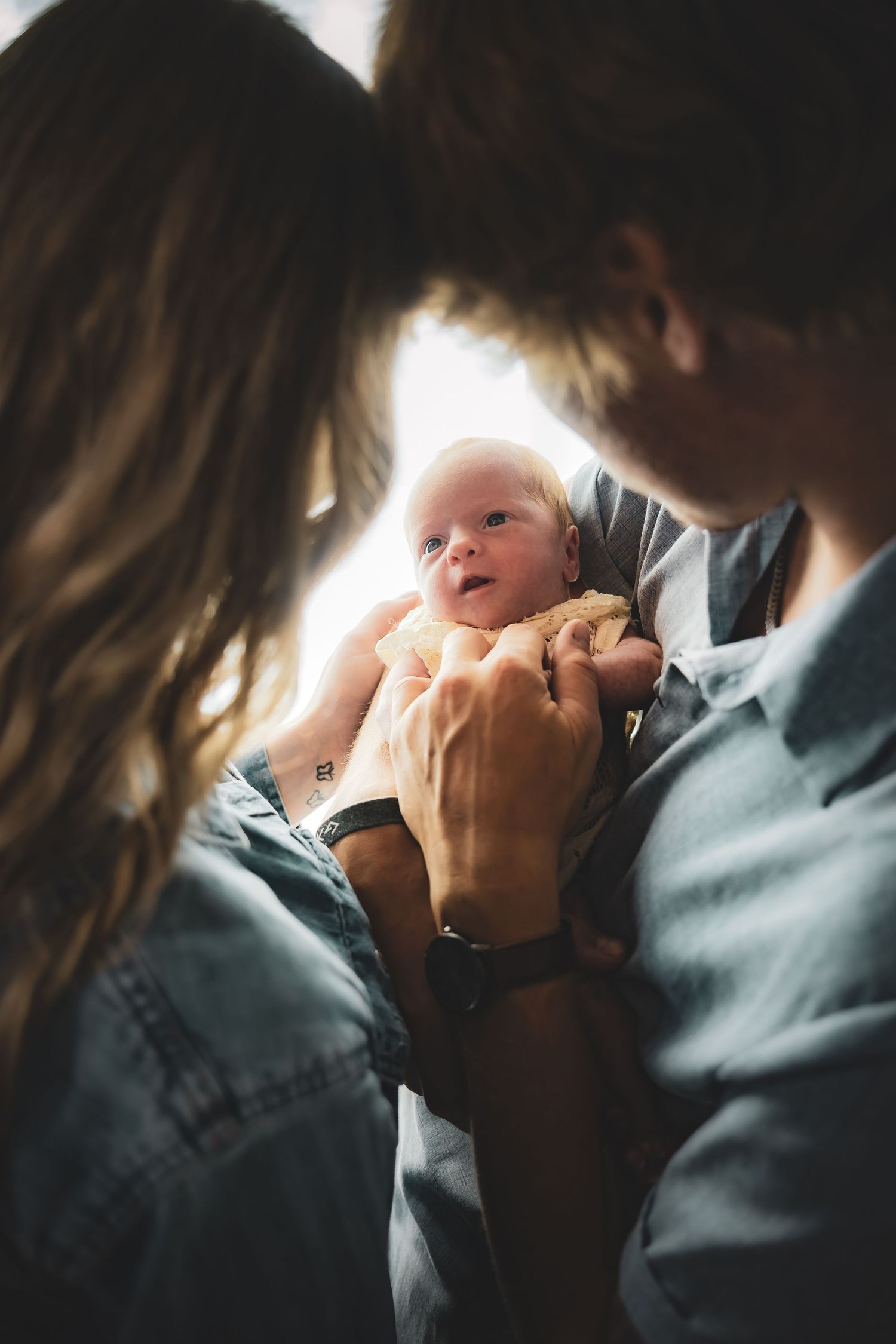 Intimate family moment captured in moody lighting with gentle embrace.