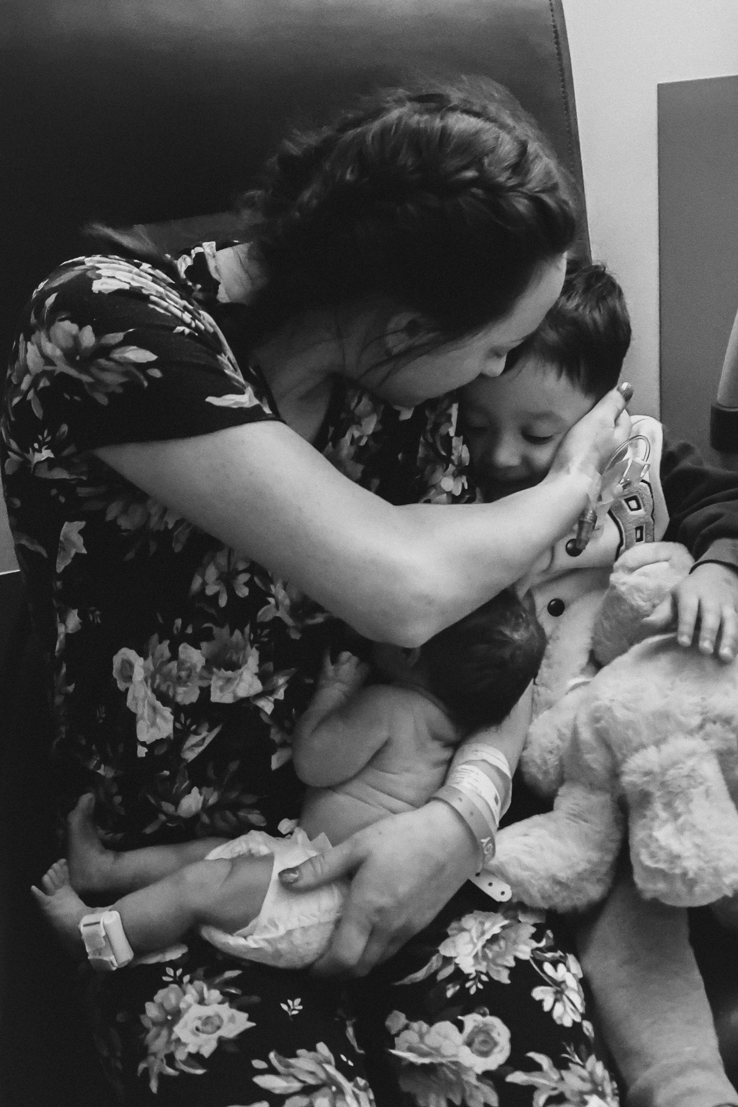 A tender moment showing a newborn baby being cradled and kissed in a series of black and white photos.