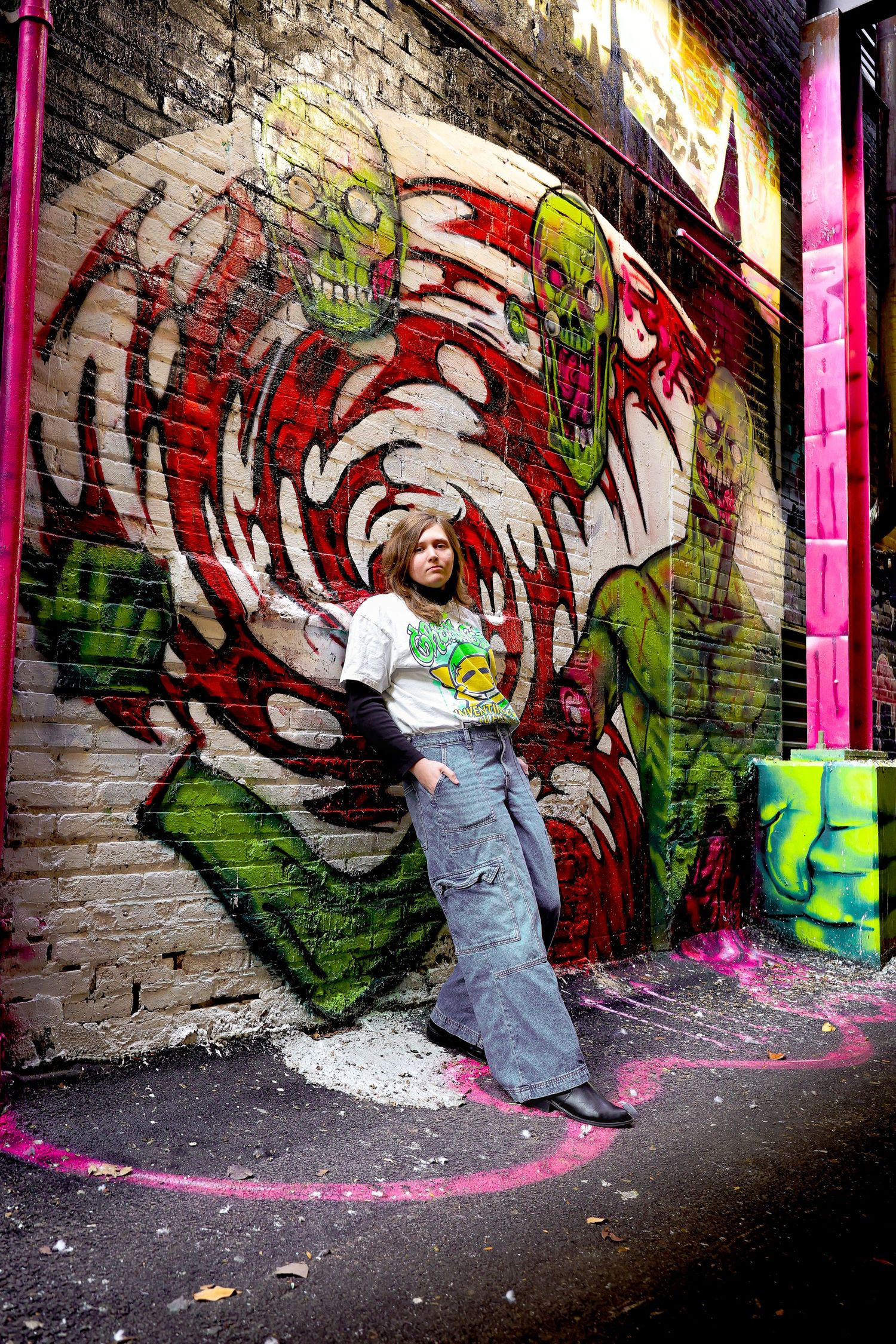 Sequence of four photos showing graffiti art on brick wall with bright pink vertical stripes and colorful designs.