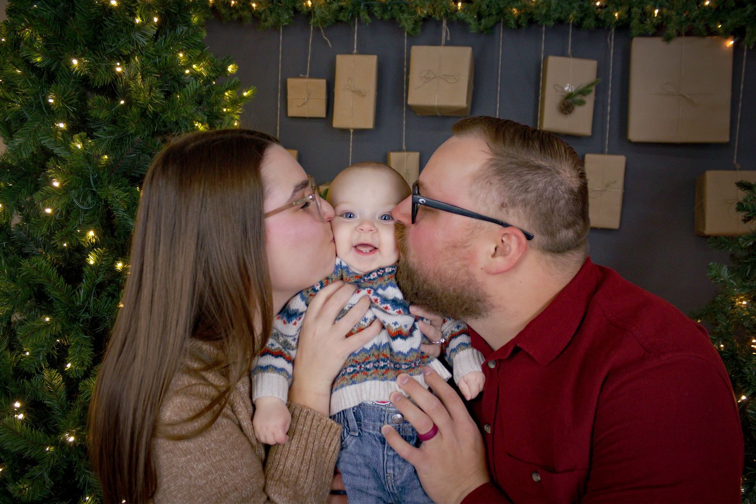 Family sharing joyful moments during holiday photo session by Christmas tree.