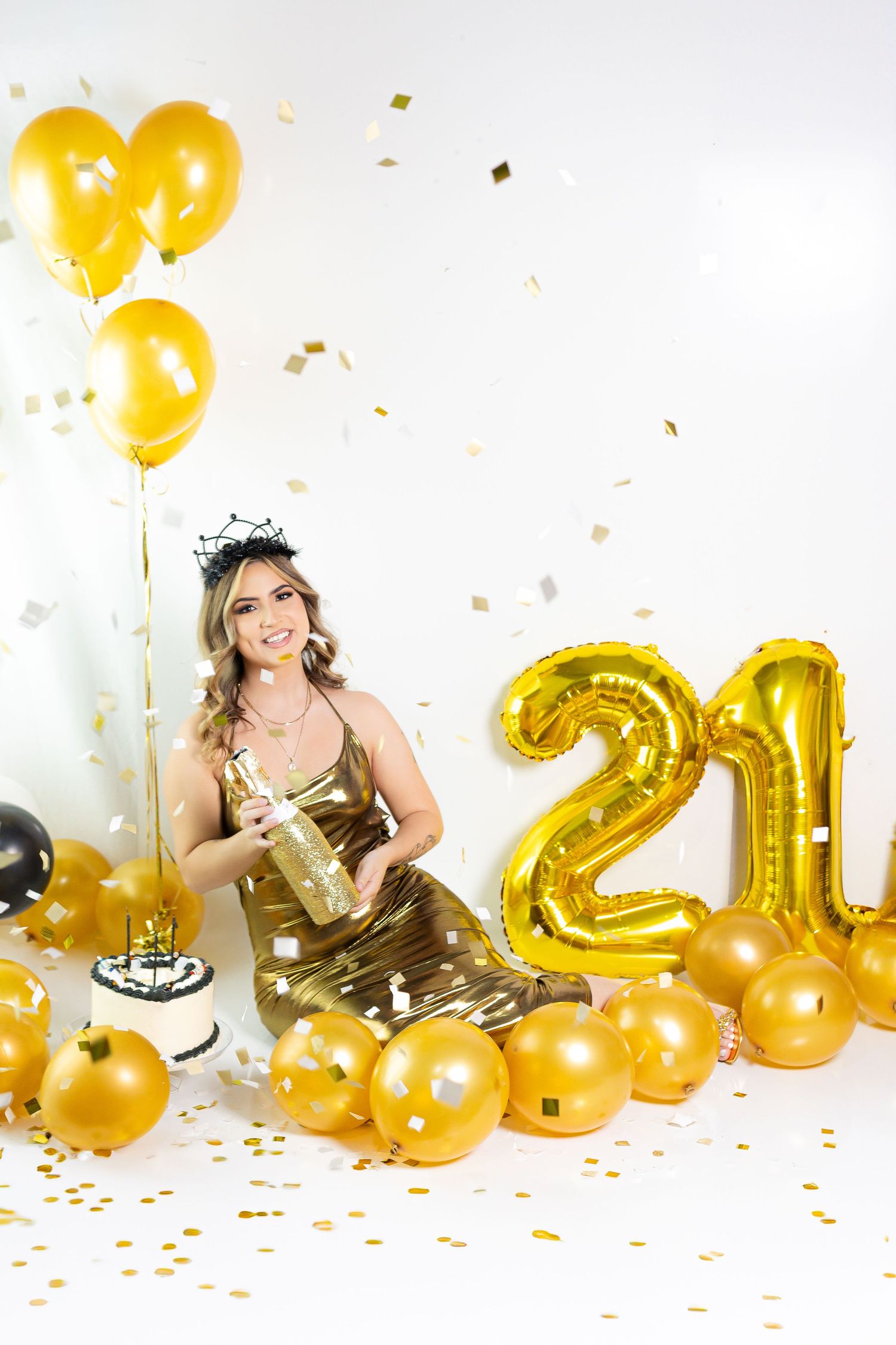21st birthday celebration with gold number balloons, cake and festive gold decor.