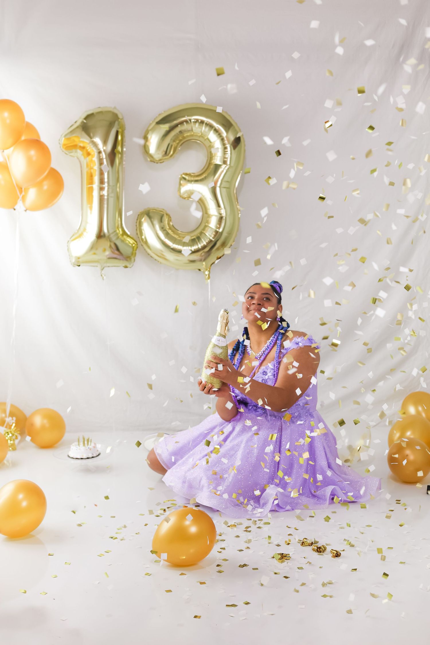 A joyful celebration scene with gold number balloons, orange decorations, and confetti against a white backdrop.