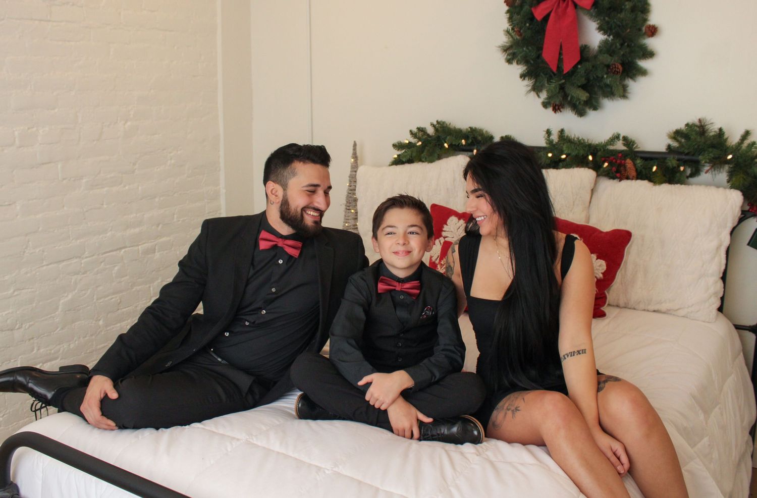 Holiday family photo session with Christmas decor and coordinated black outfits.