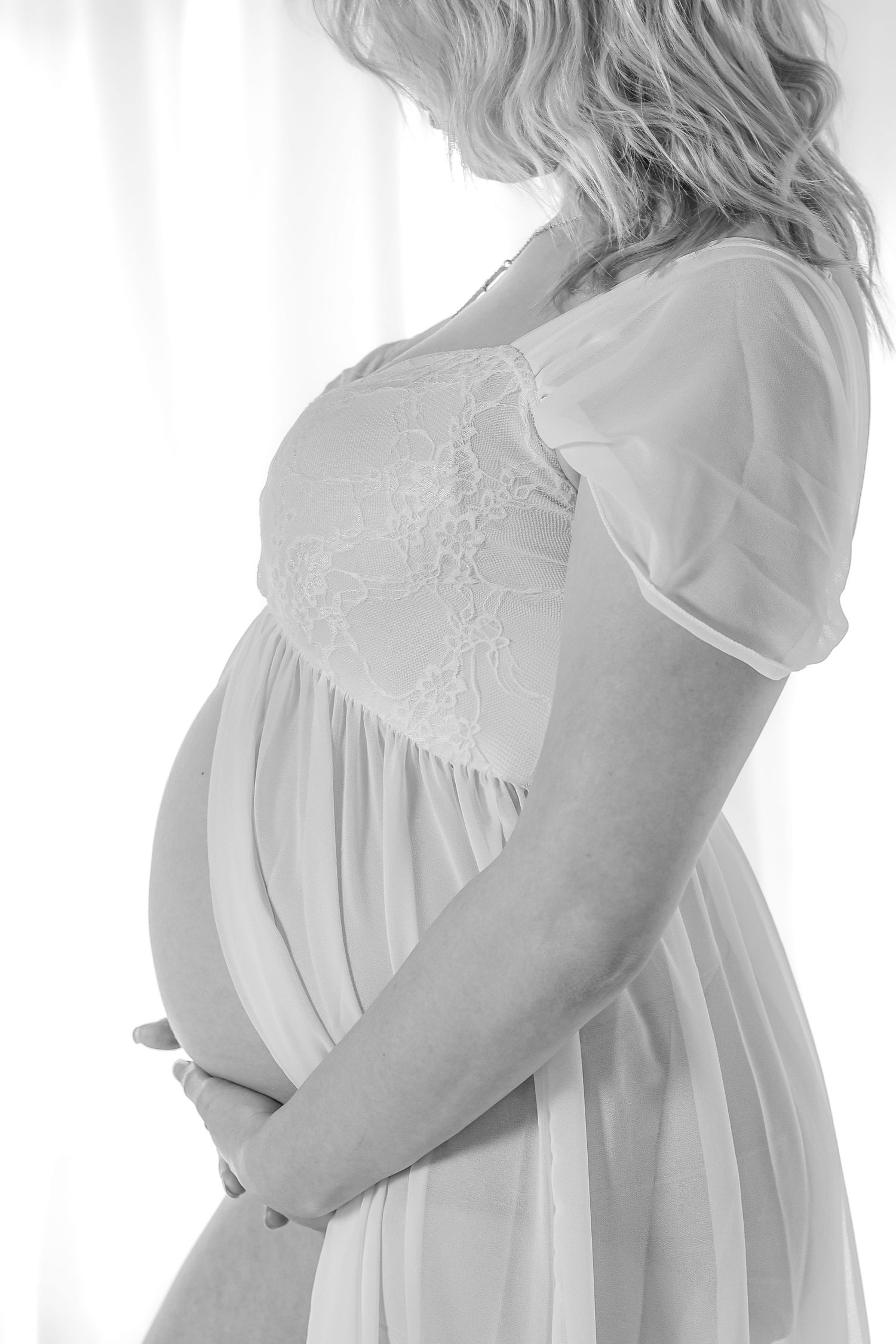 Side view maternity progression photos with flowing white dress against light backdrop.