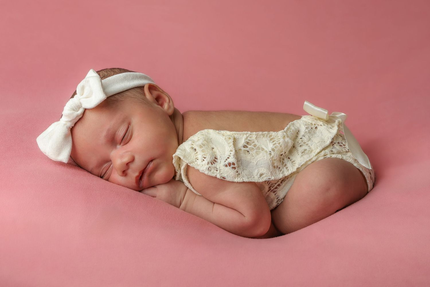 A series of peaceful newborn baby portraits on a soft pink backdrop showing different sleeping positions and poses.