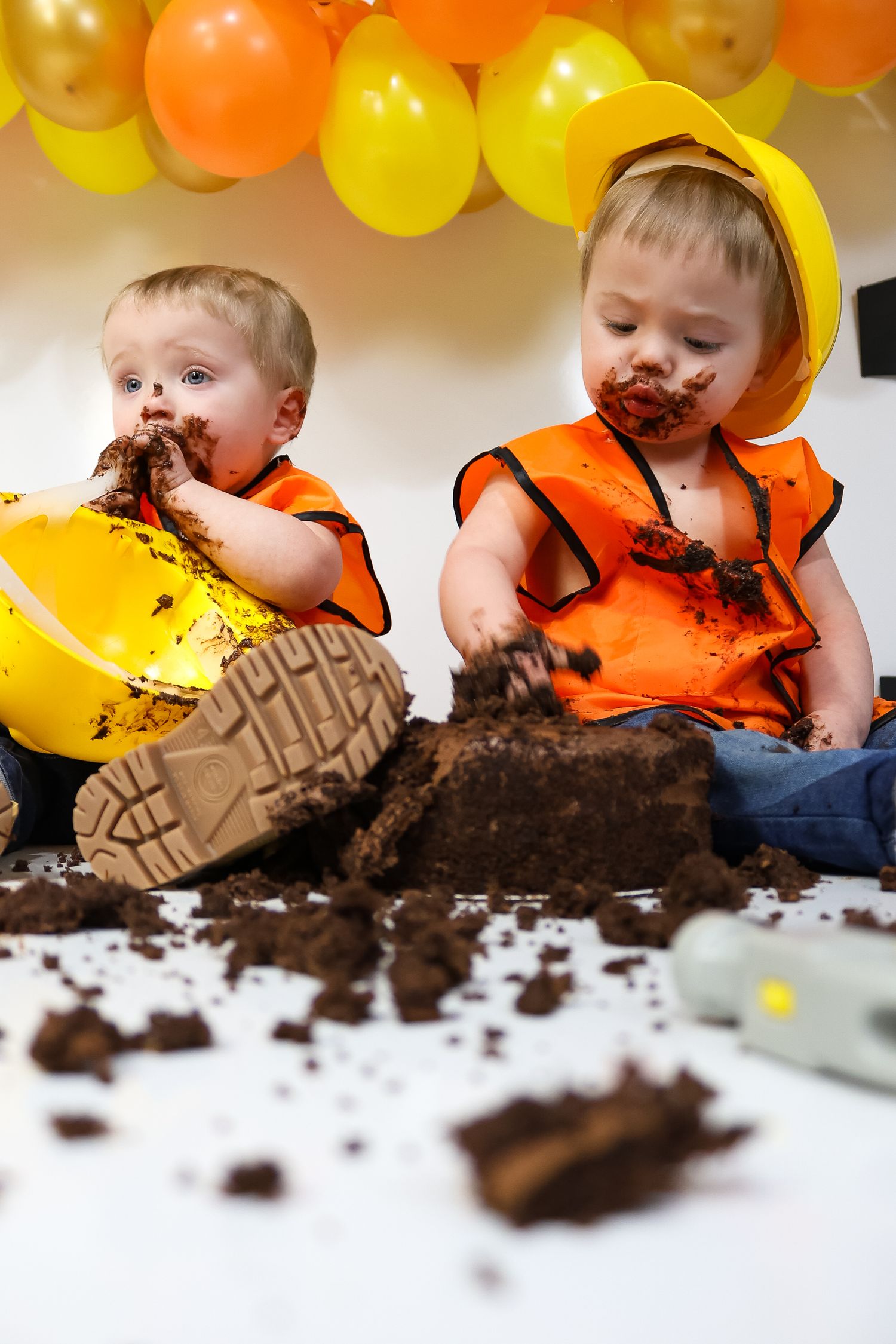 Chocolate cake smash photoshoot with construction theme decorations and balloons.