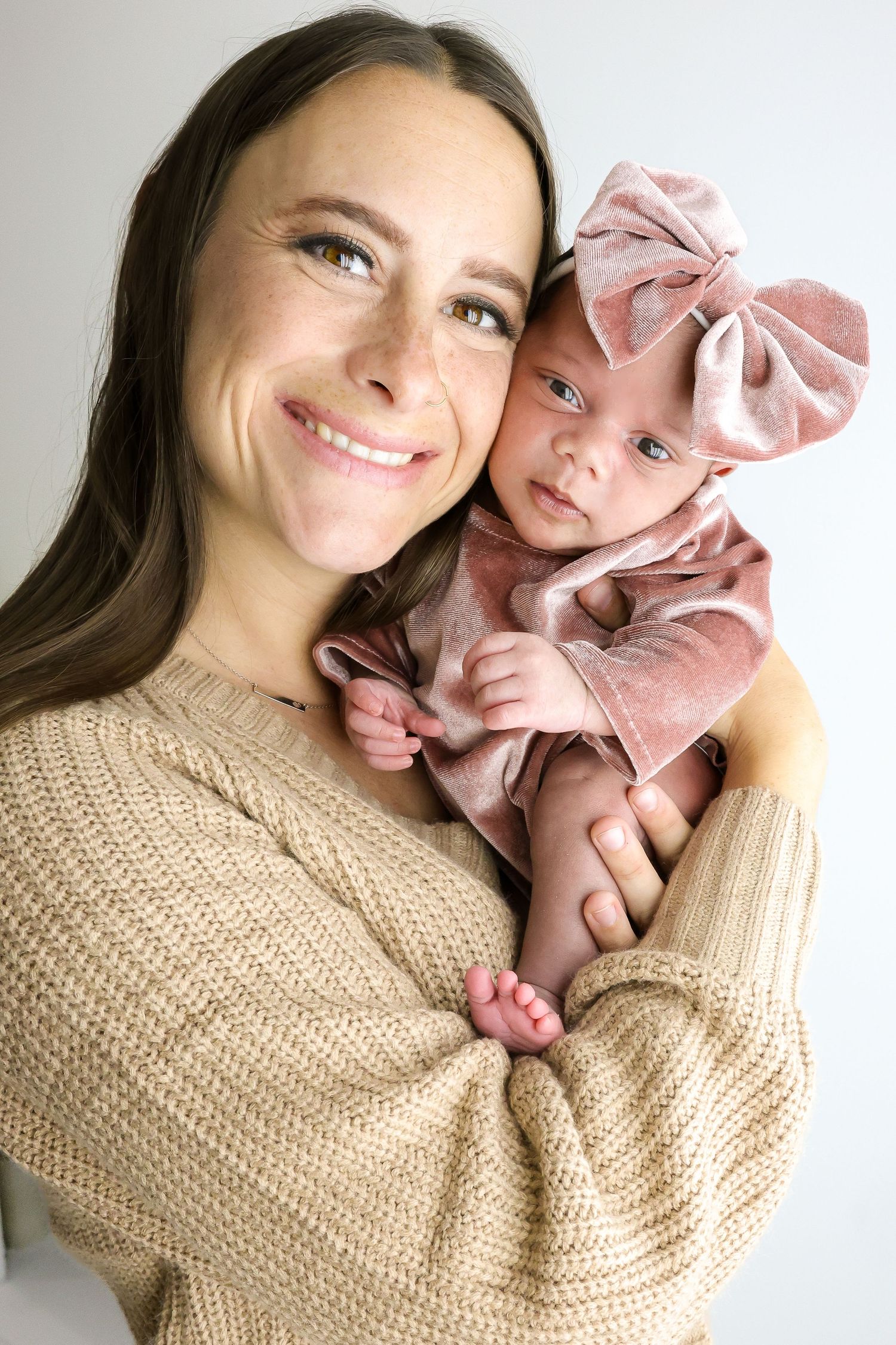 A heartwarming series of photos showing tender moments between a parent and newborn baby in cozy beige knitwear.