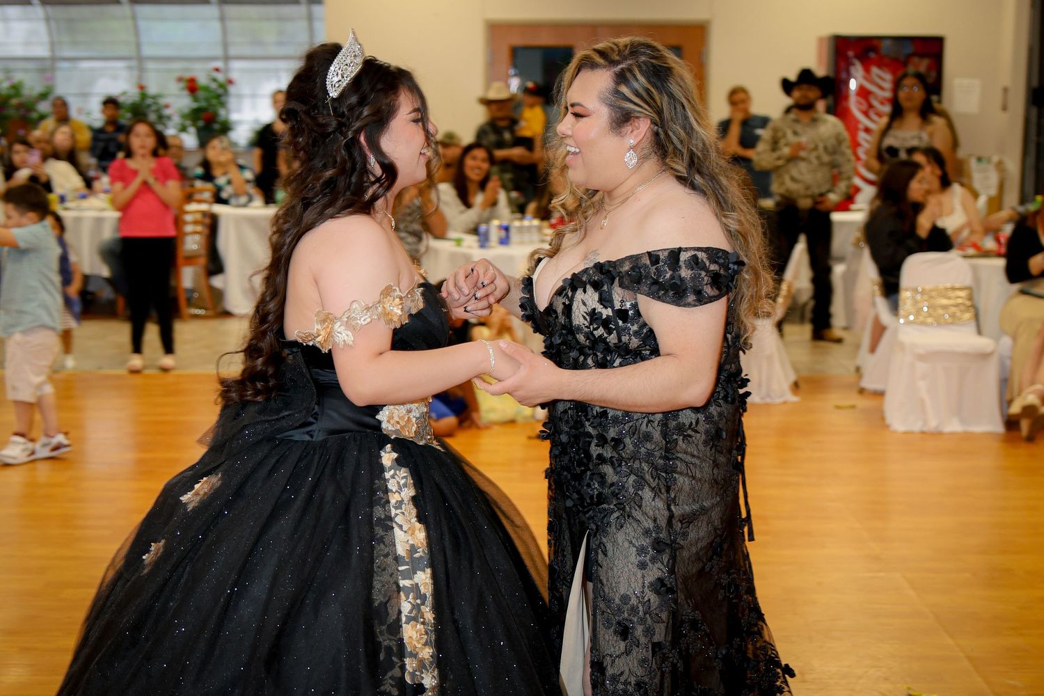 Celebration in a reception hall with formal black and gold attire.