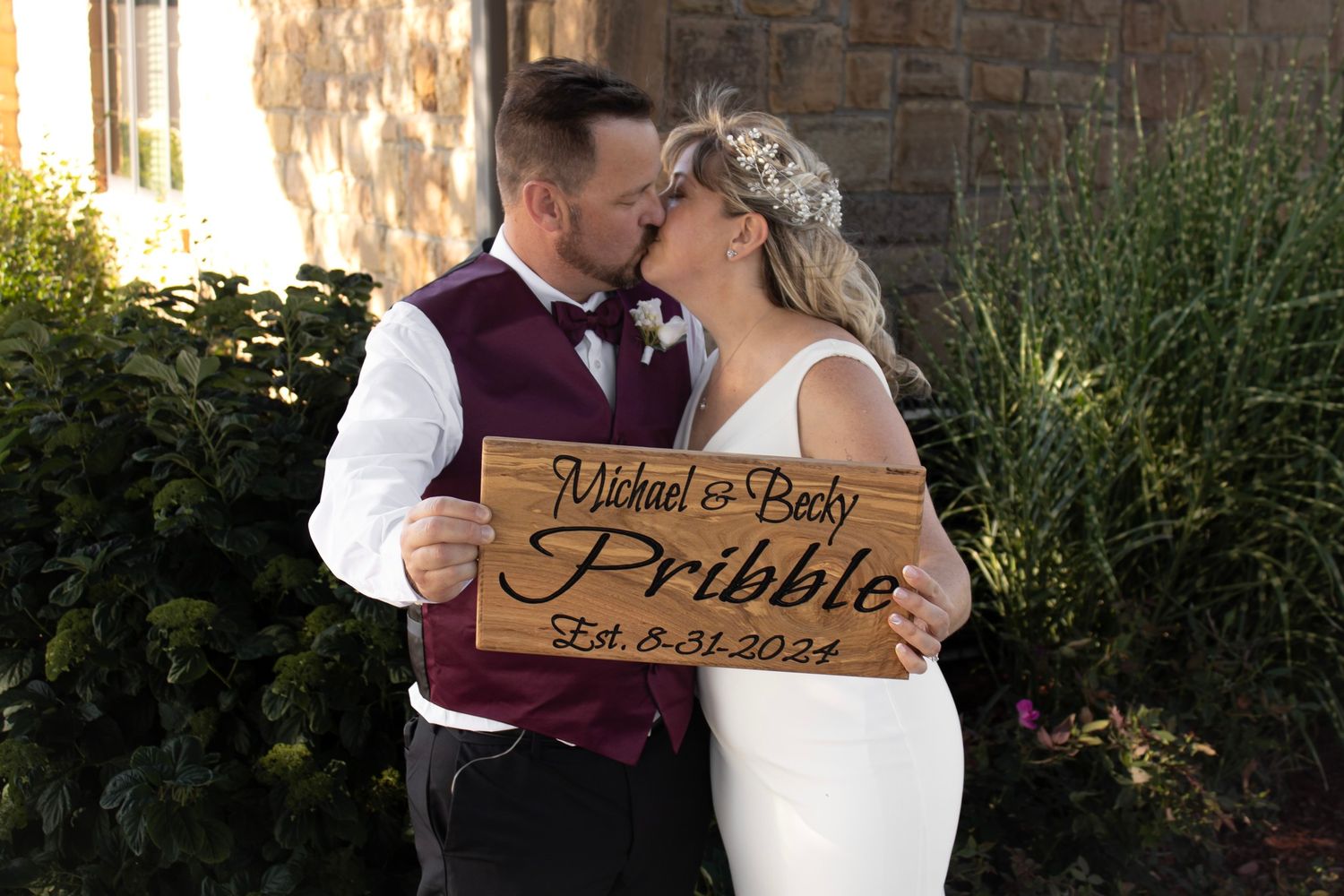 Rustic wooden wedding signs displayed outdoors against natural scenery.