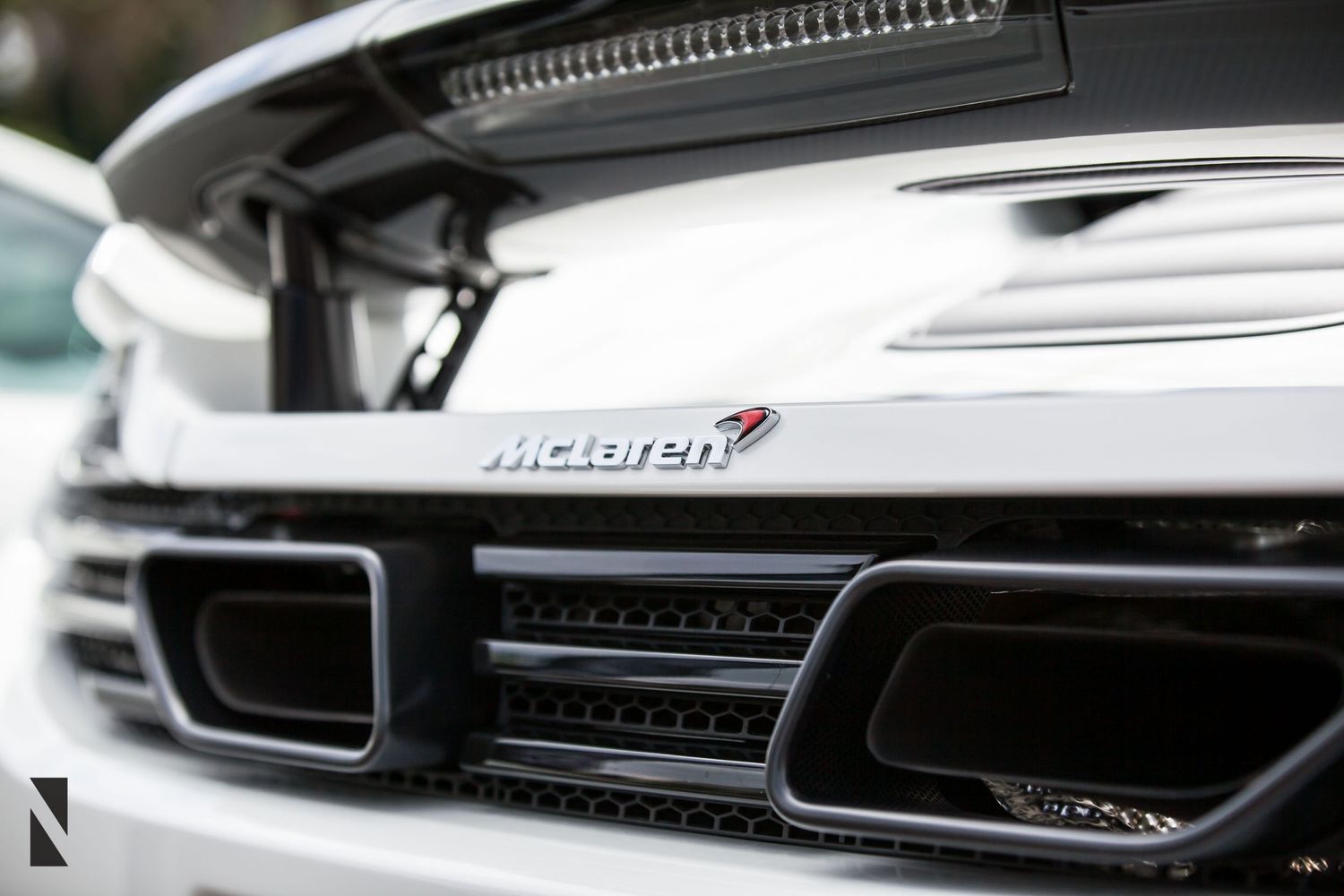 Close-up detail shot of a McLaren supercar's front grille and ventilation system.