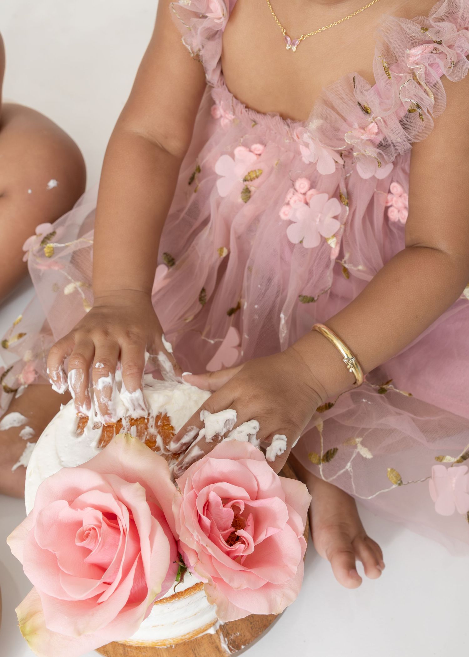 Pink roses and hands with white nail polish showcase a romantic manicure design with delicate floral touches.