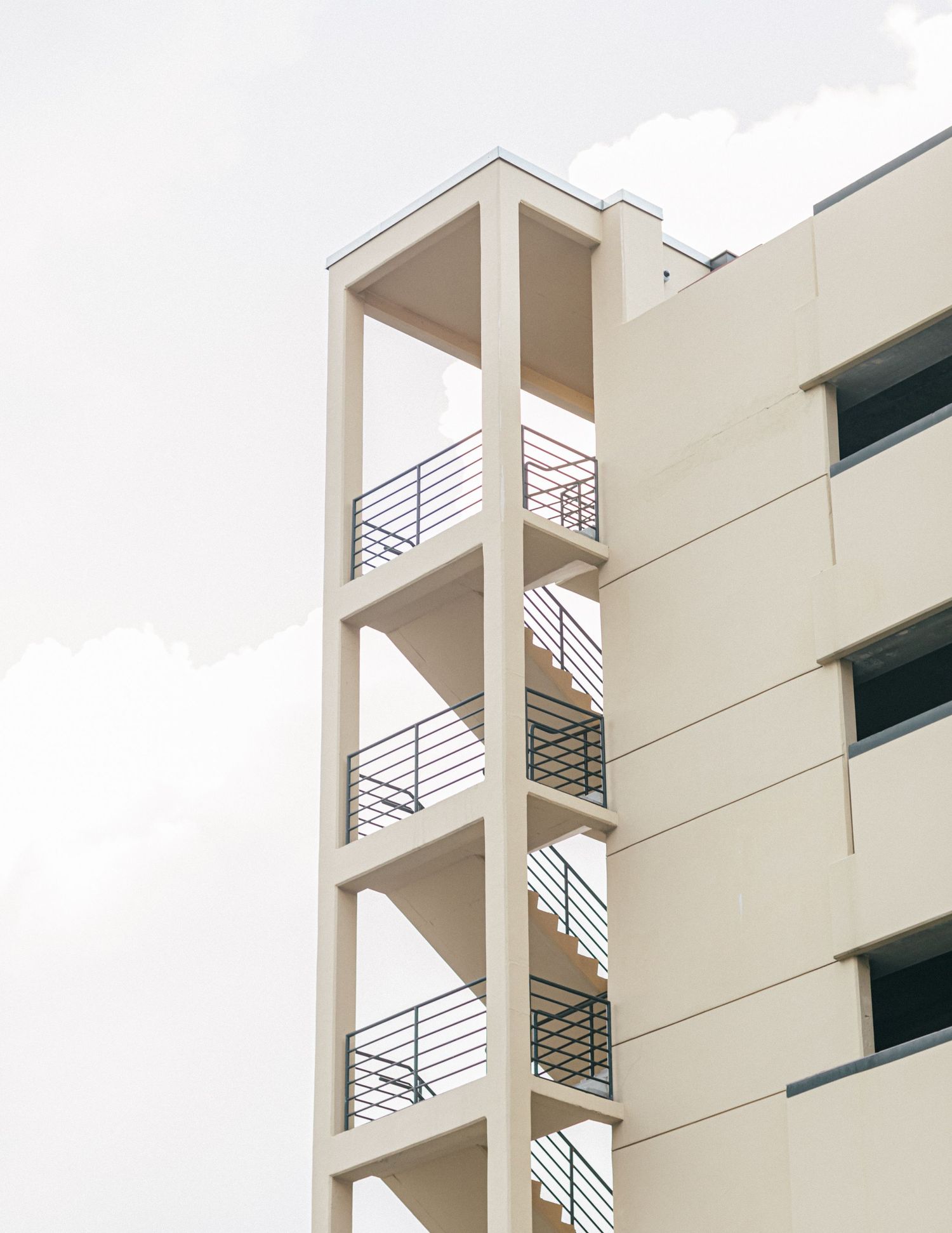 Minimalist architectural detail of white building stairwell with geometric railings.