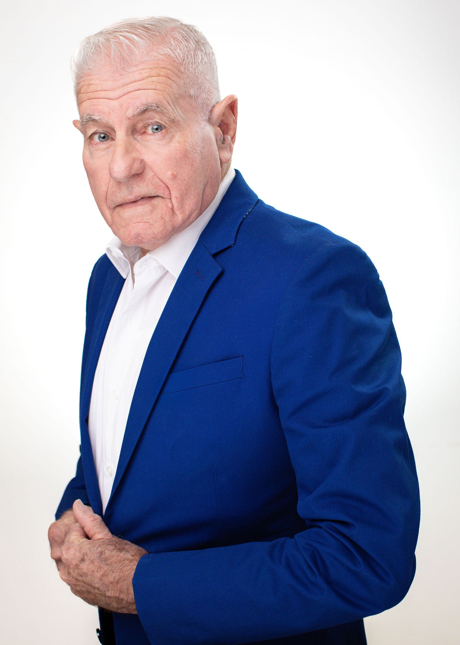 Professional headshot of senior executive wearing bright blue blazer against white background.