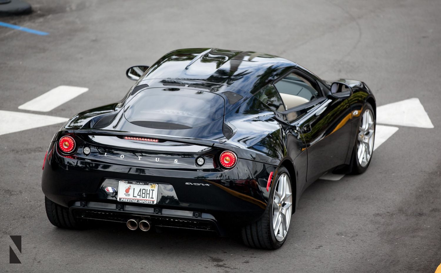 Rear view of a black Ferrari sports car with distinctive dual exhaust and aerodynamic design.