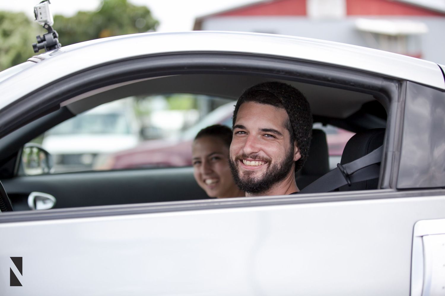 People enjoying a drive in a white modern car with sunlight streaming through the windows.
