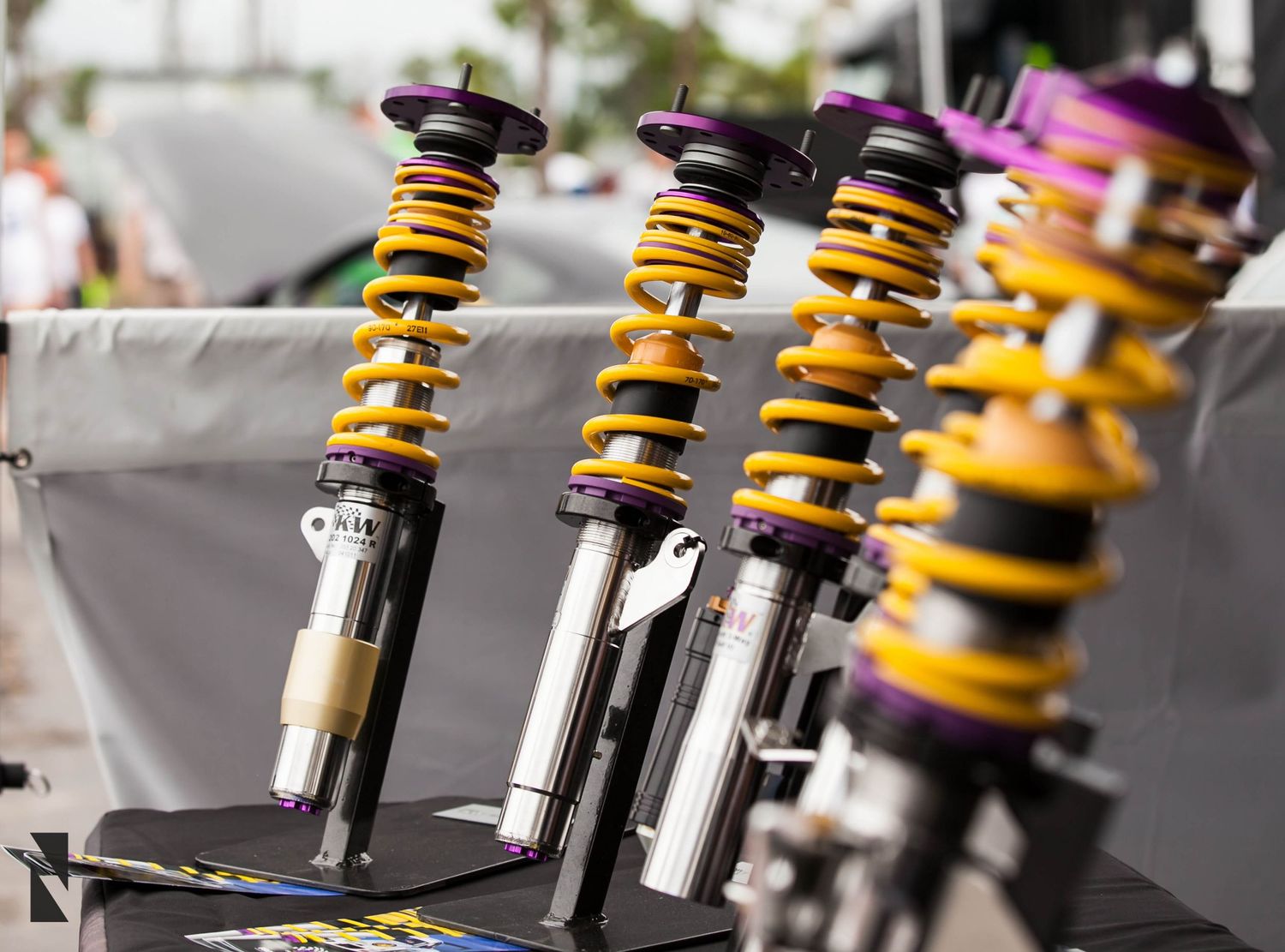 Close-up of yellow and black performance coilover suspension springs and shocks arranged in a row.