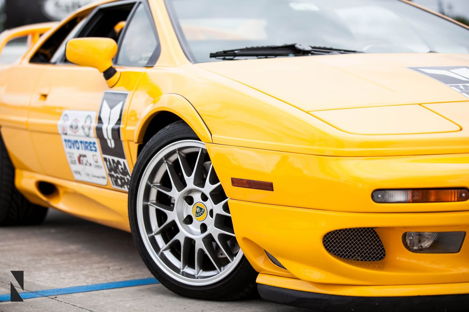 A yellow Lamborghini sports car with custom wheels showcasing its front wheel and headlight detail.
