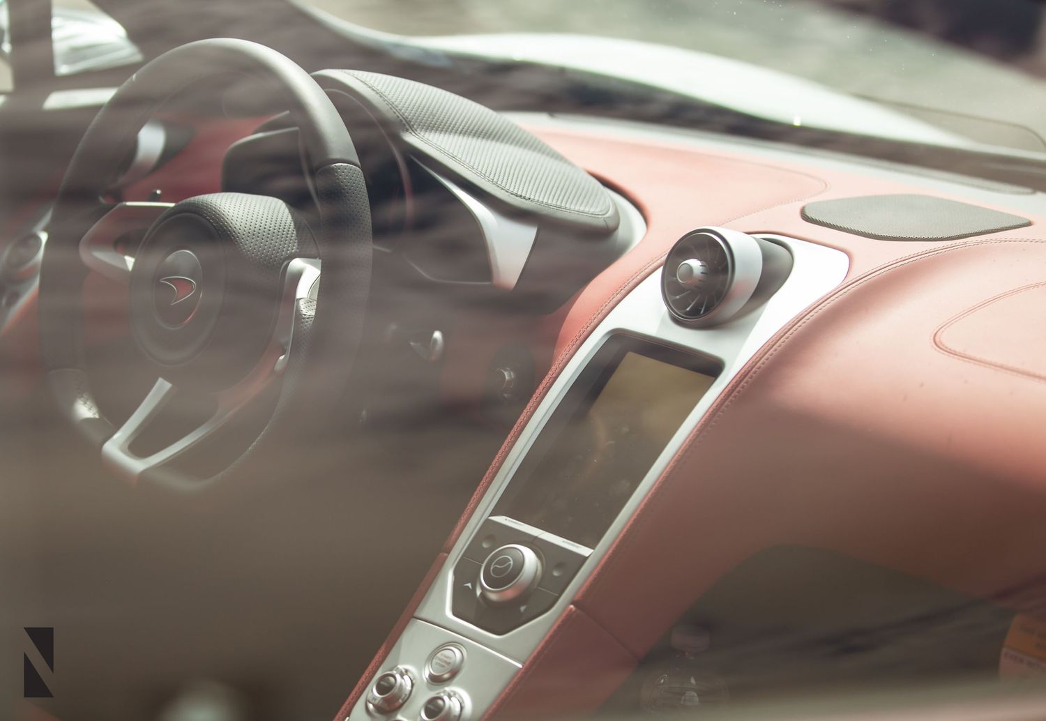 Interior view of a luxury car dashboard showing sleek controls and display screens.
