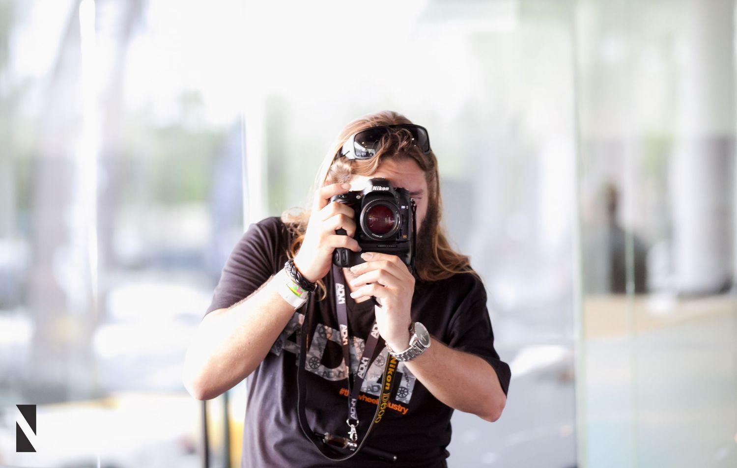 Photographer using a professional DSLR camera to capture photos in a bright indoor setting.