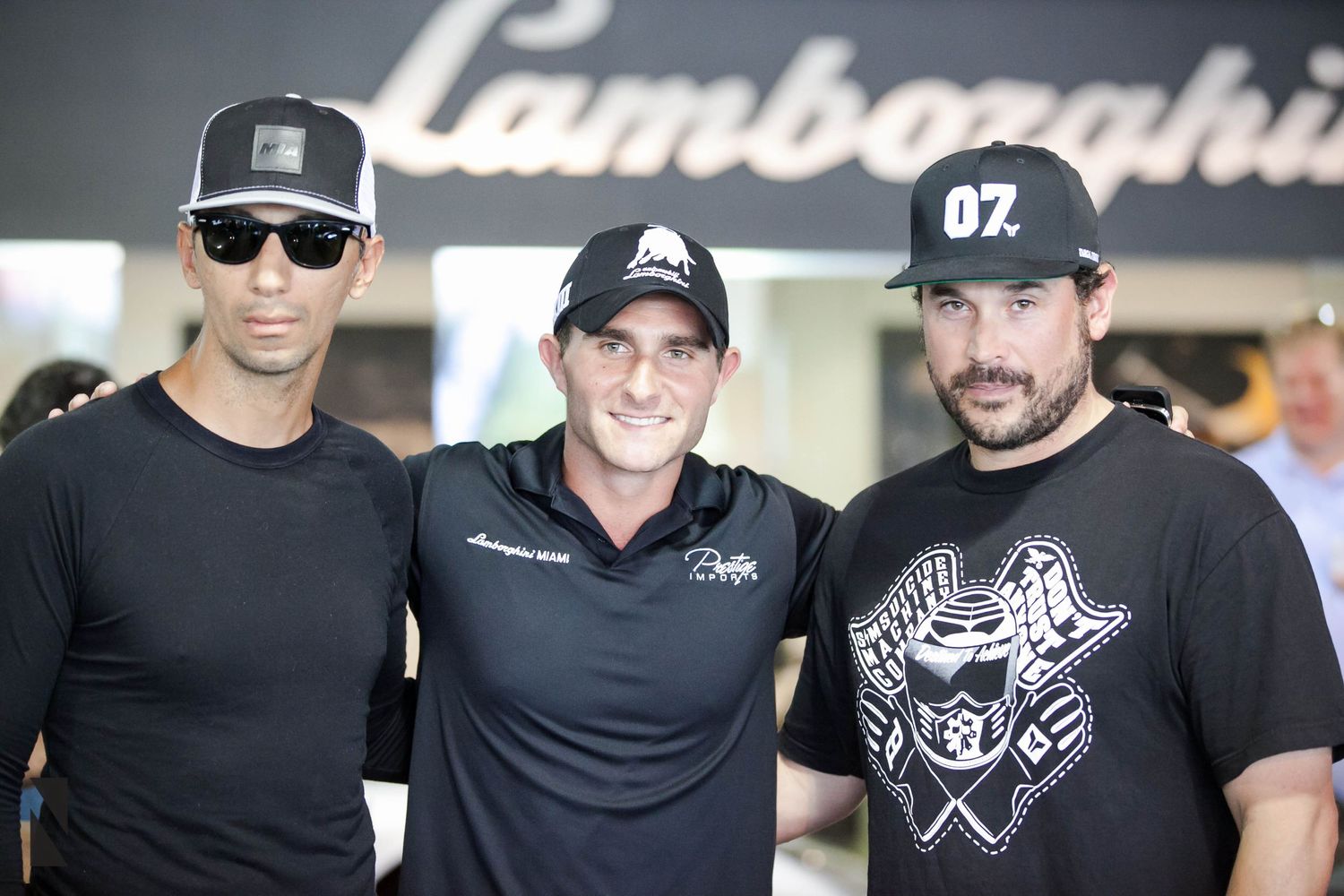 Group photo taken at a Lamborghini dealership or event showing attendees in casual attire.
