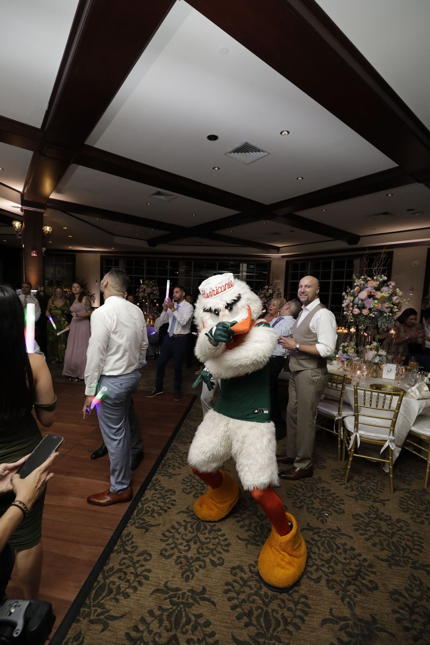 A series of candid photos from a reception or event showing people interacting on a carpeted floor with decorative patterns.