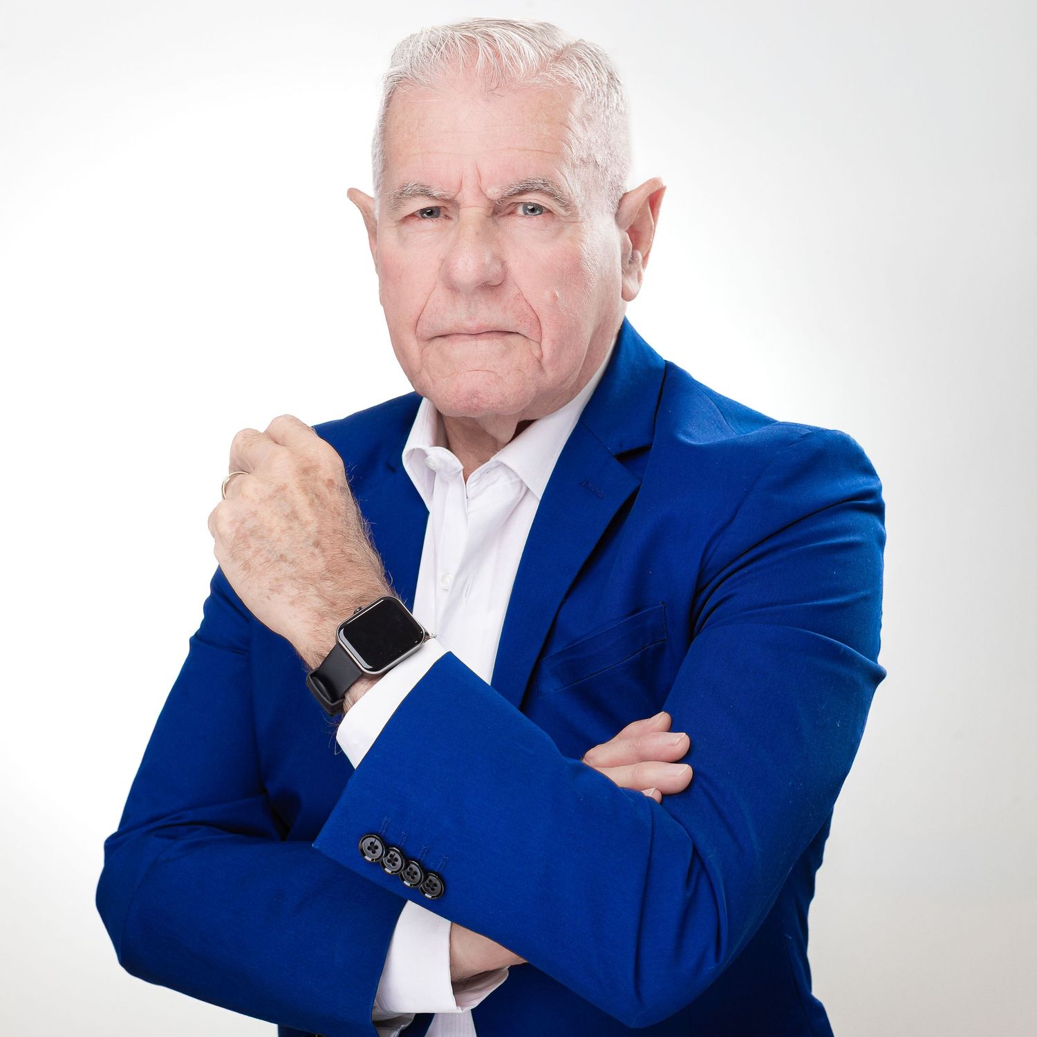 Professional wearing a bright blue blazer and smart watch against white background.