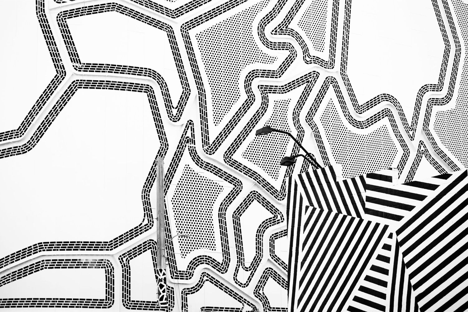 Abstract black and white pattern with geometric shapes and diagonal striped sections creating a bold graphic design.