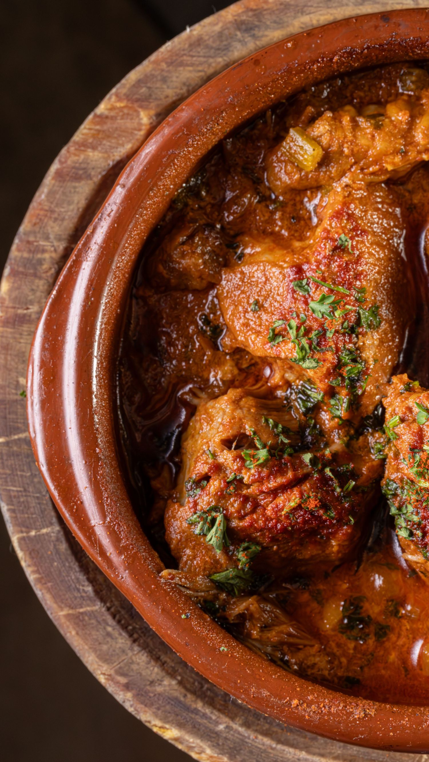 A series of cooking progress shots showing braised chicken getting more saucy and caramelized in a clay pot over time.