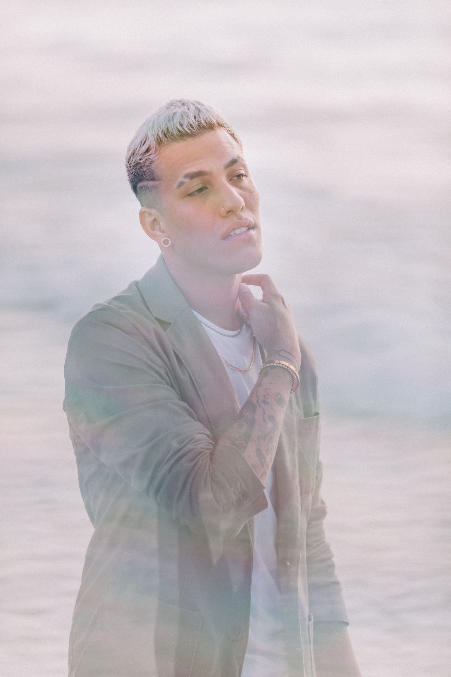 Dreamy portrait in soft pink lighting with person wearing casual jacket.