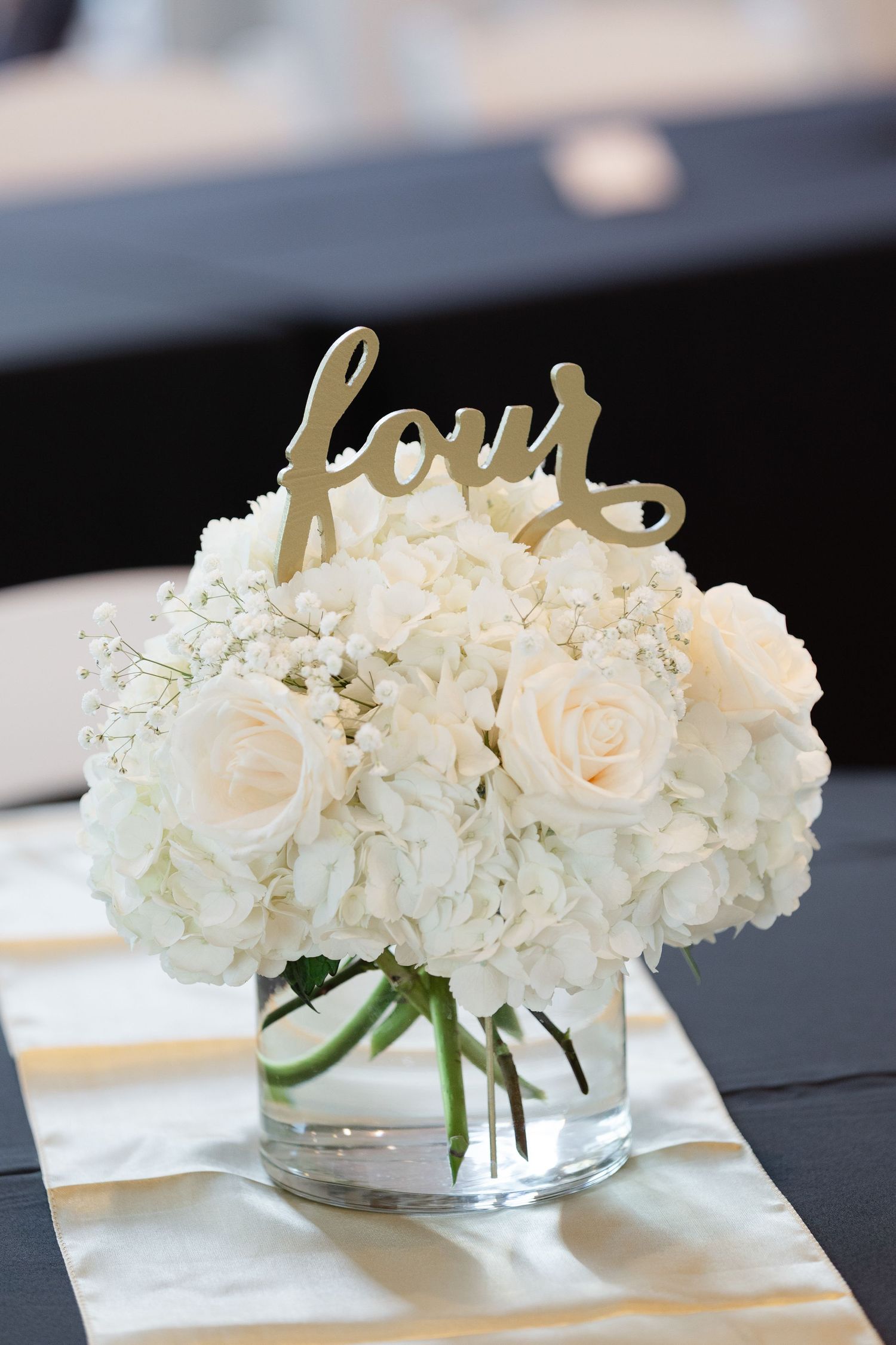 White roses and hydrangeas arranged in clear glass vases create an elegant wedding table centerpiece display.